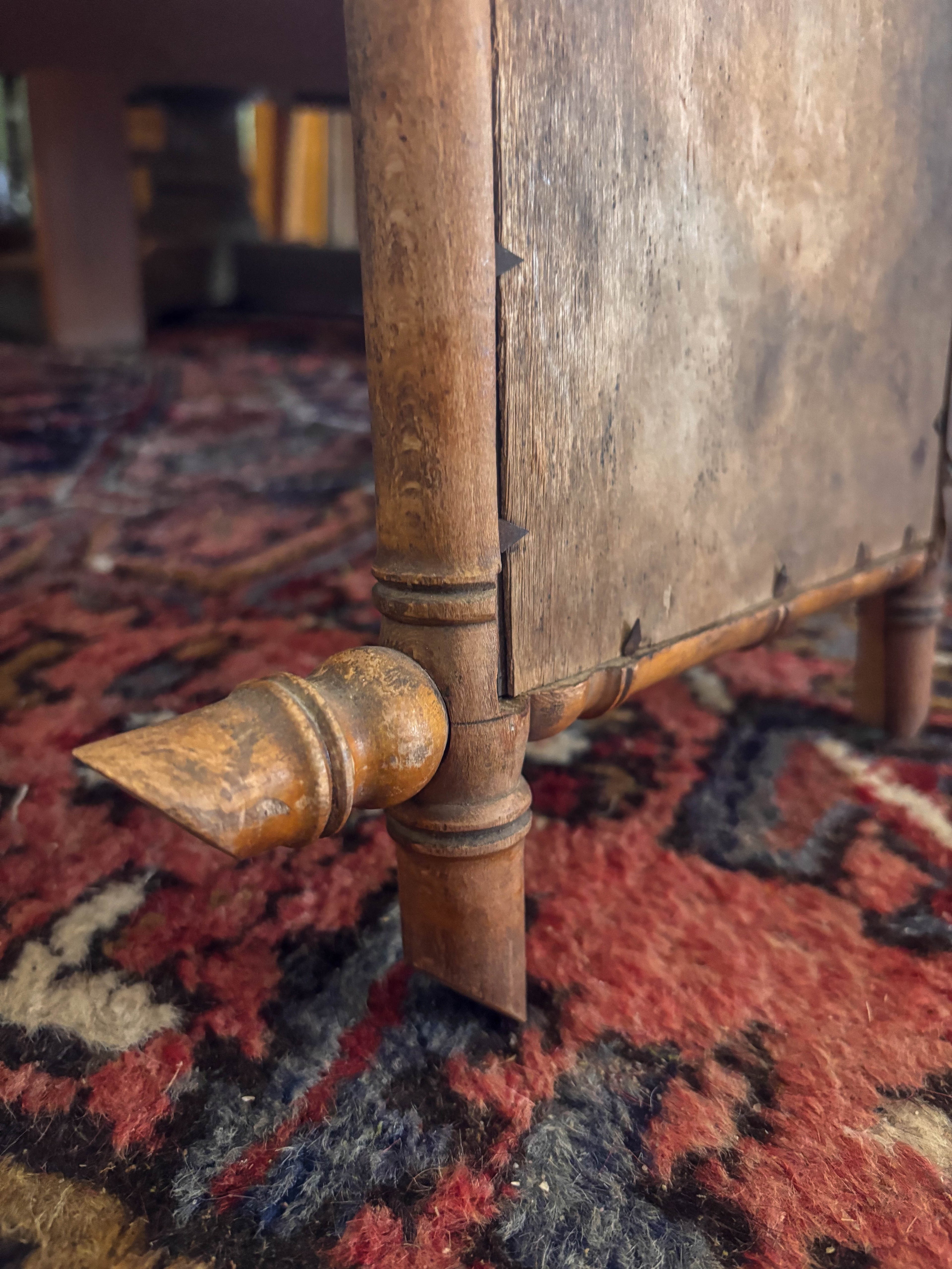 Close-up of a corner of a bamboo mirror with a patterned rug in the background
