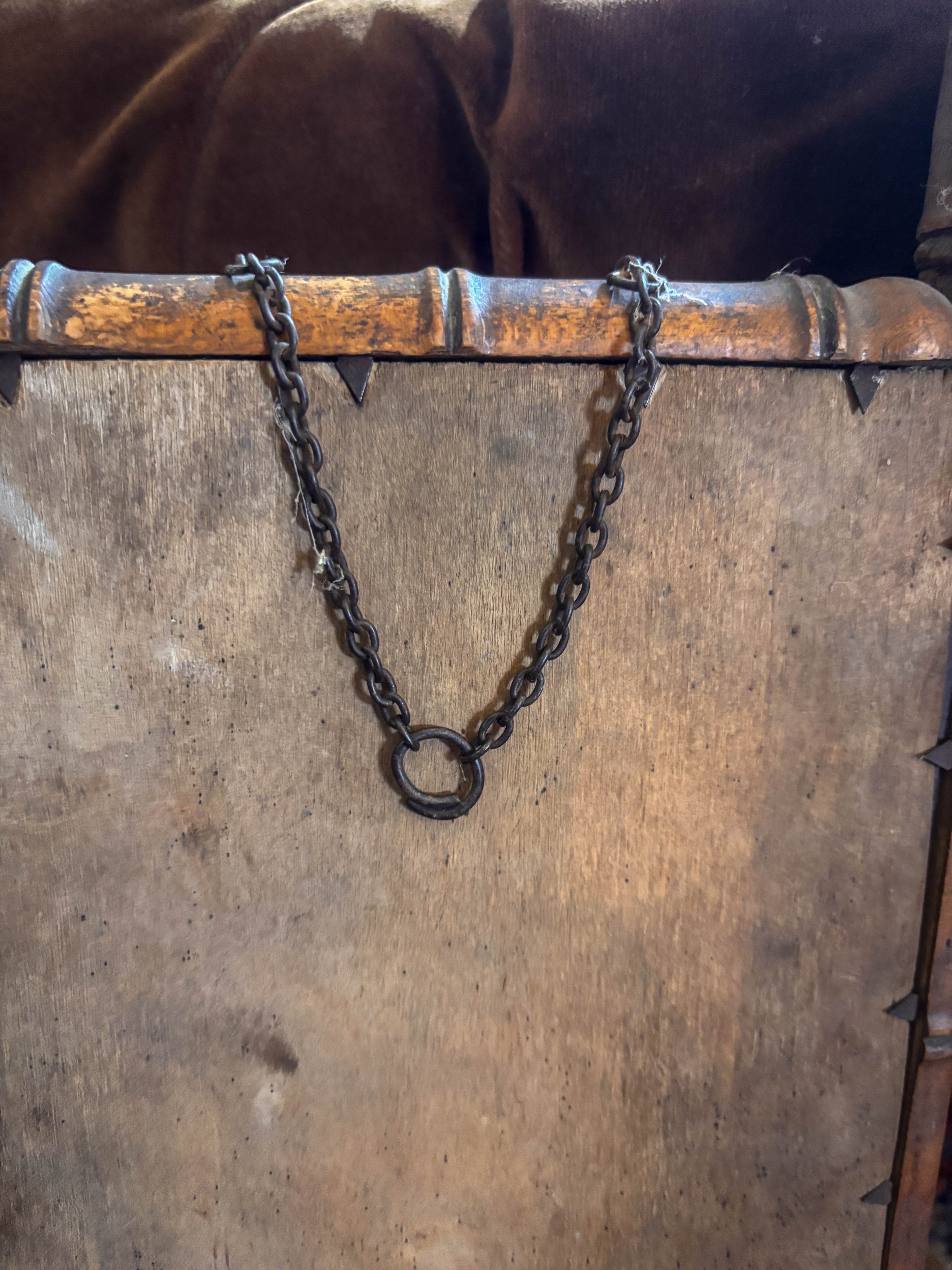 Chain attached to a wooden frame with a rustic background