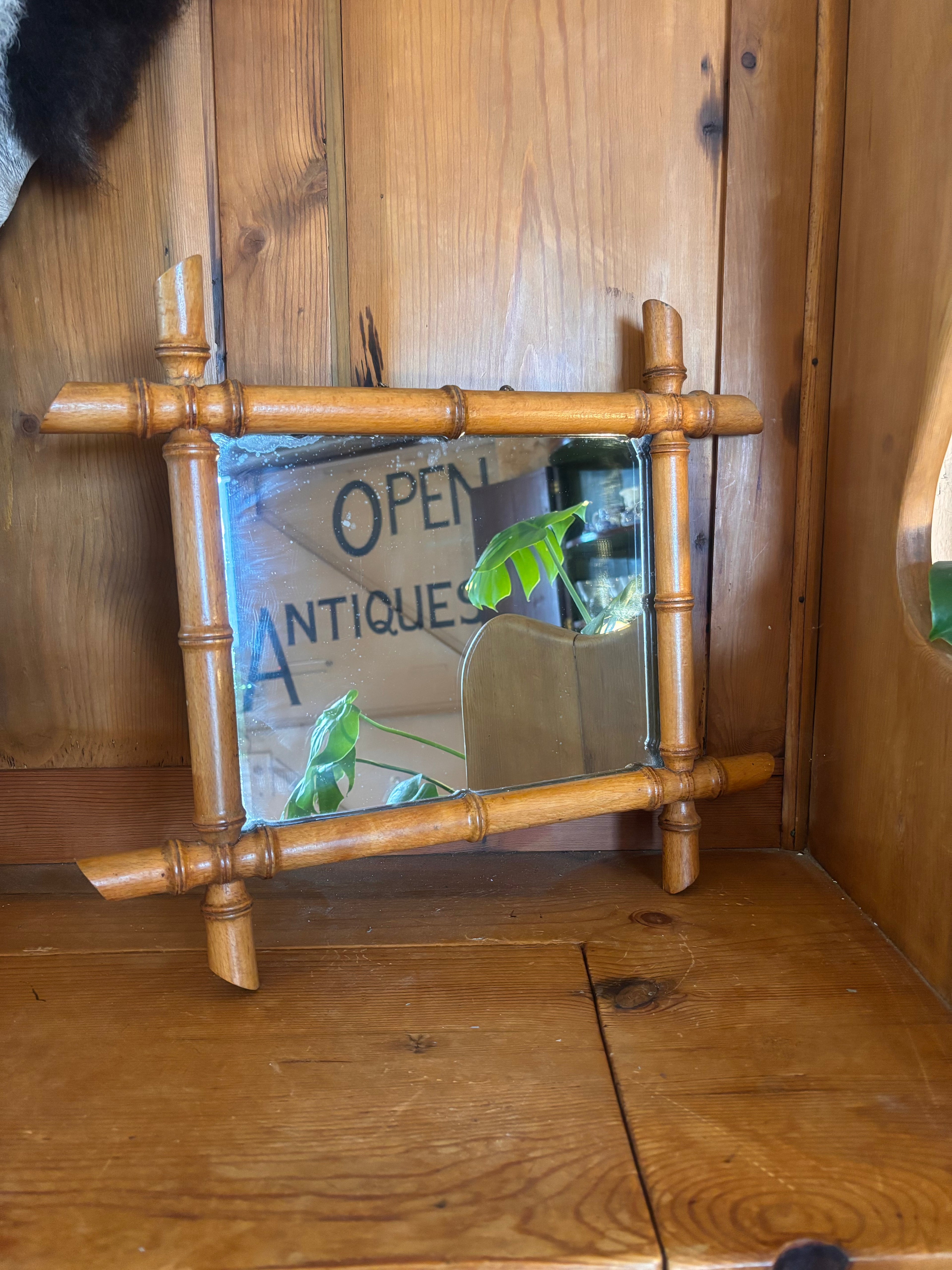 Wooden mirror with bamboo-style frame on a wooden surface