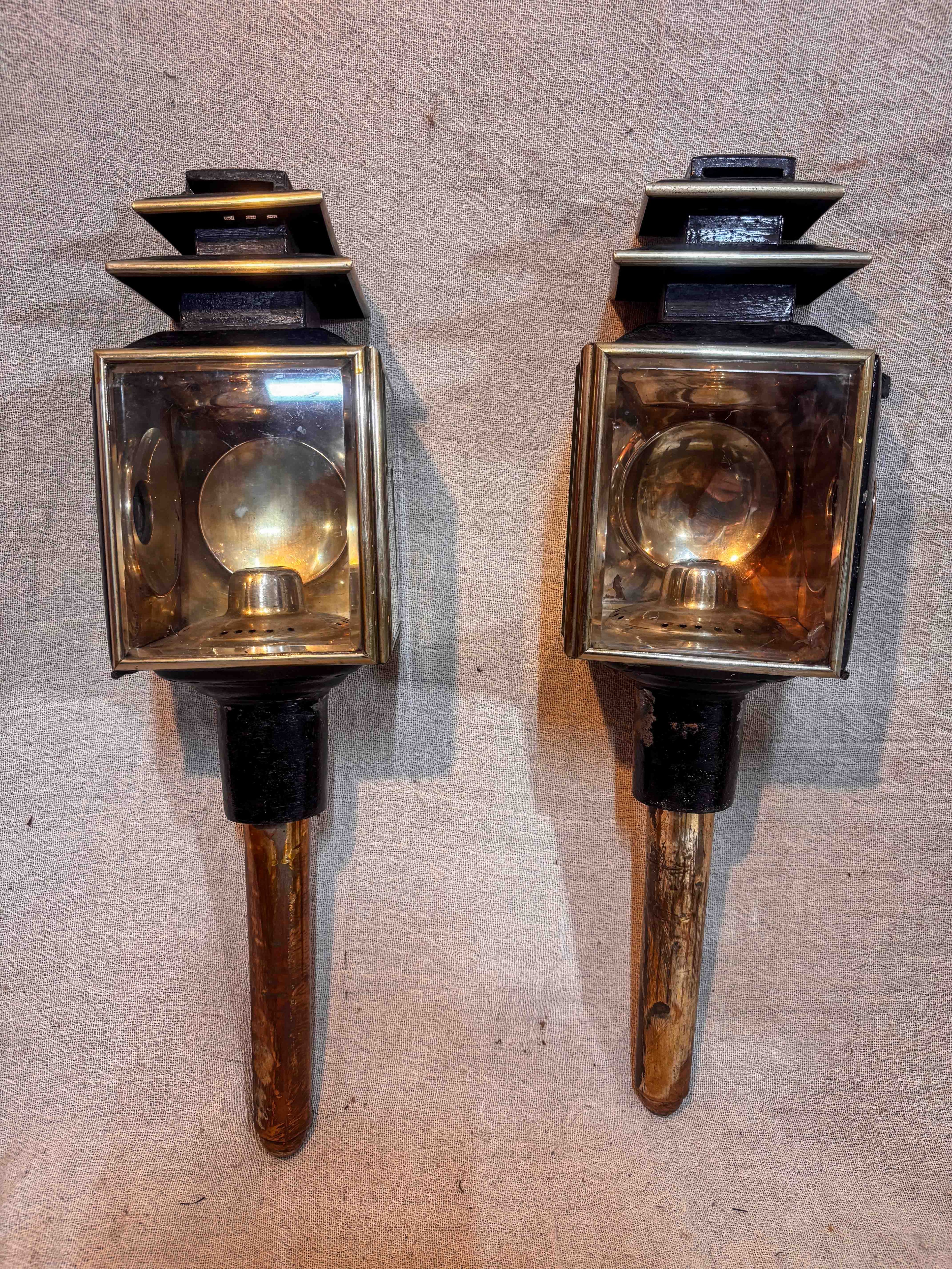 pair of antique carriage lamps on a textured surface.