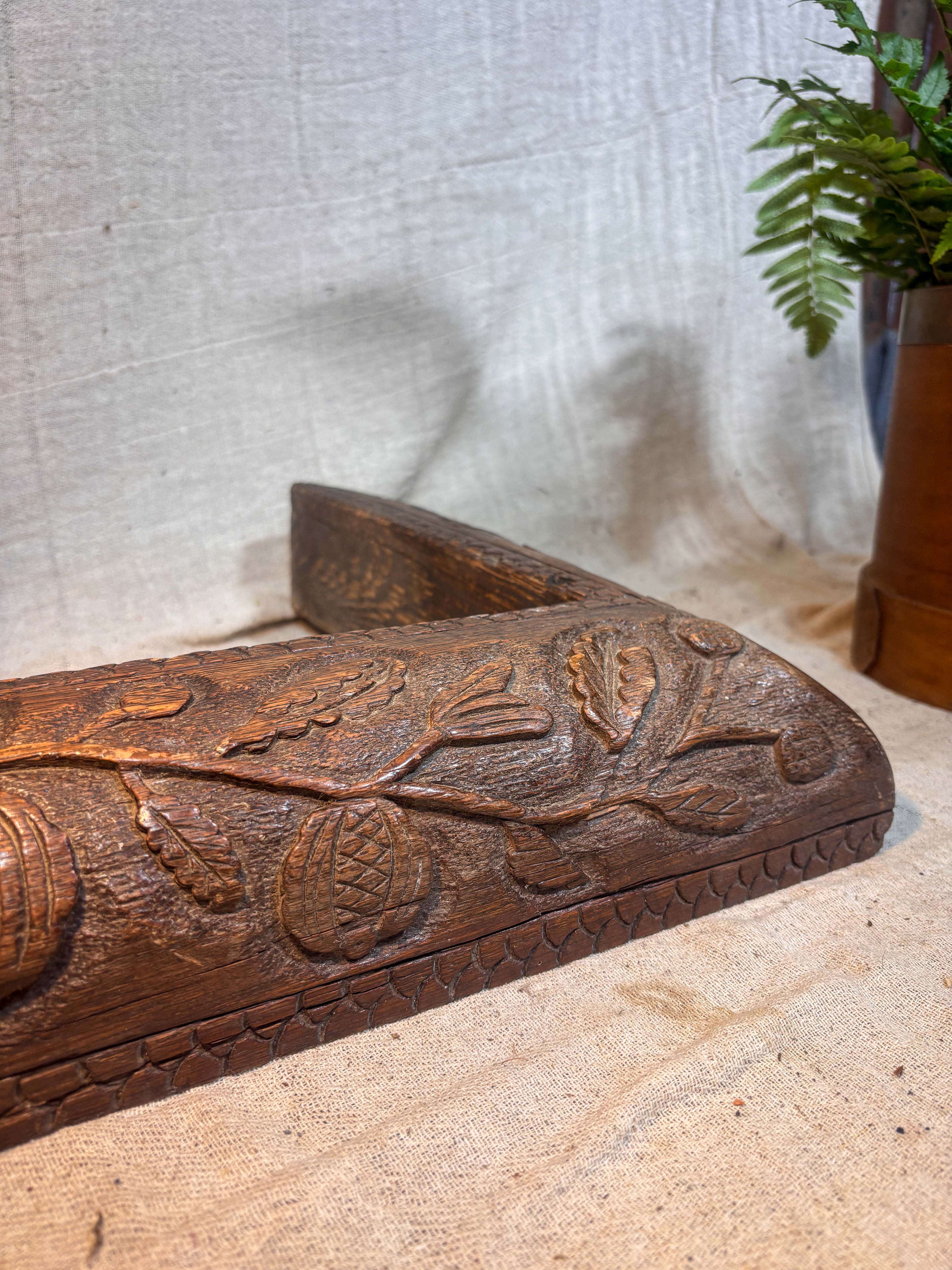 Wooden fireplace fender with intricate carvings on a textured surface
