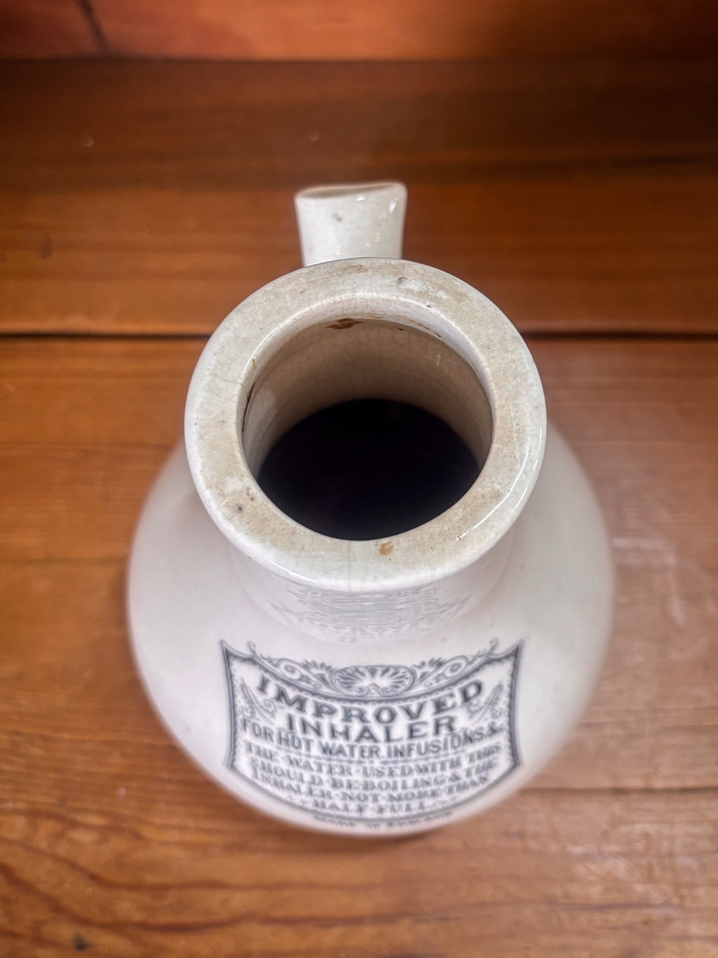 Vintage-style ceramic inhaler on a wooden surface