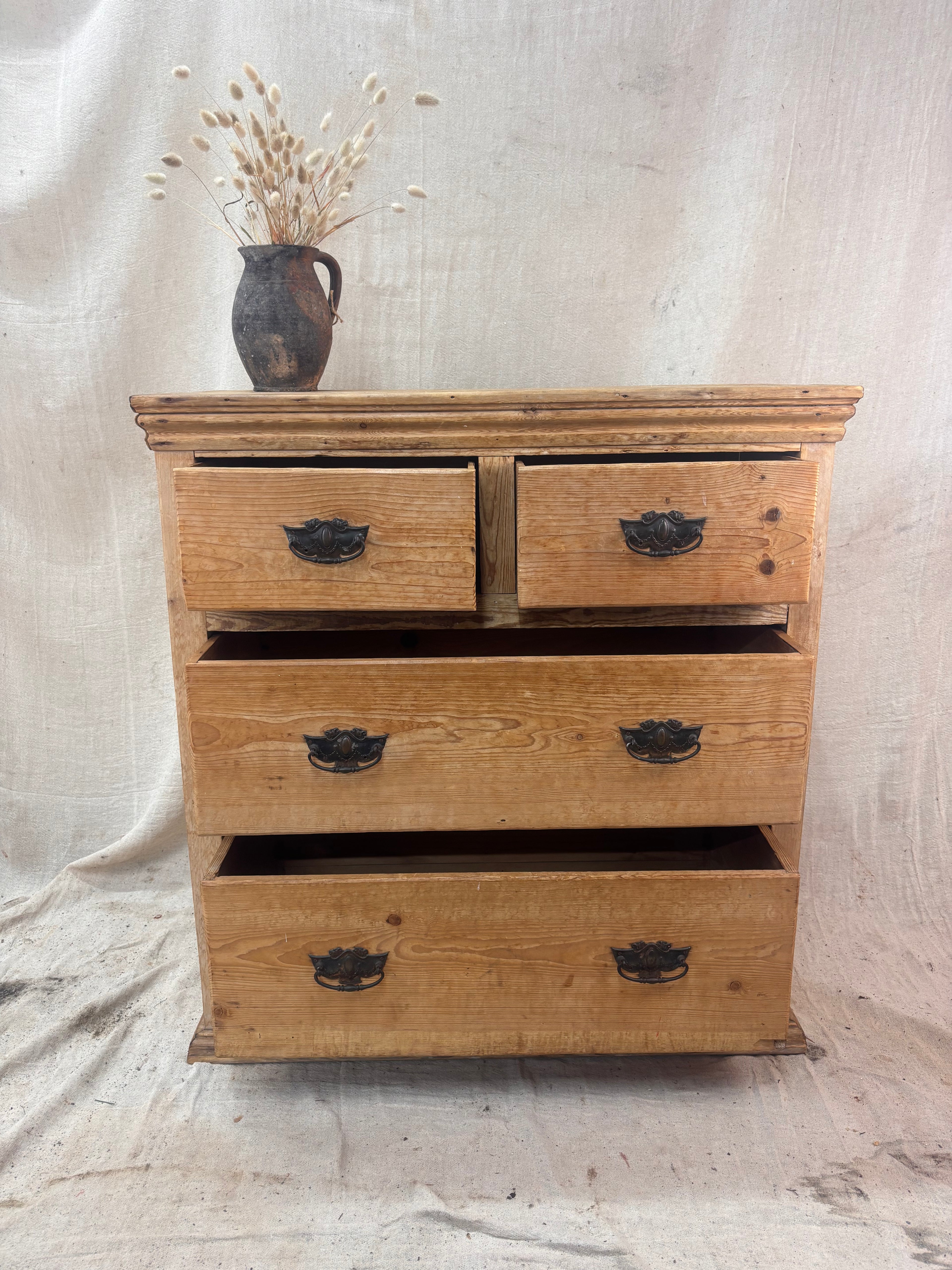 Wooden dresser with four drawers on a textured beige background