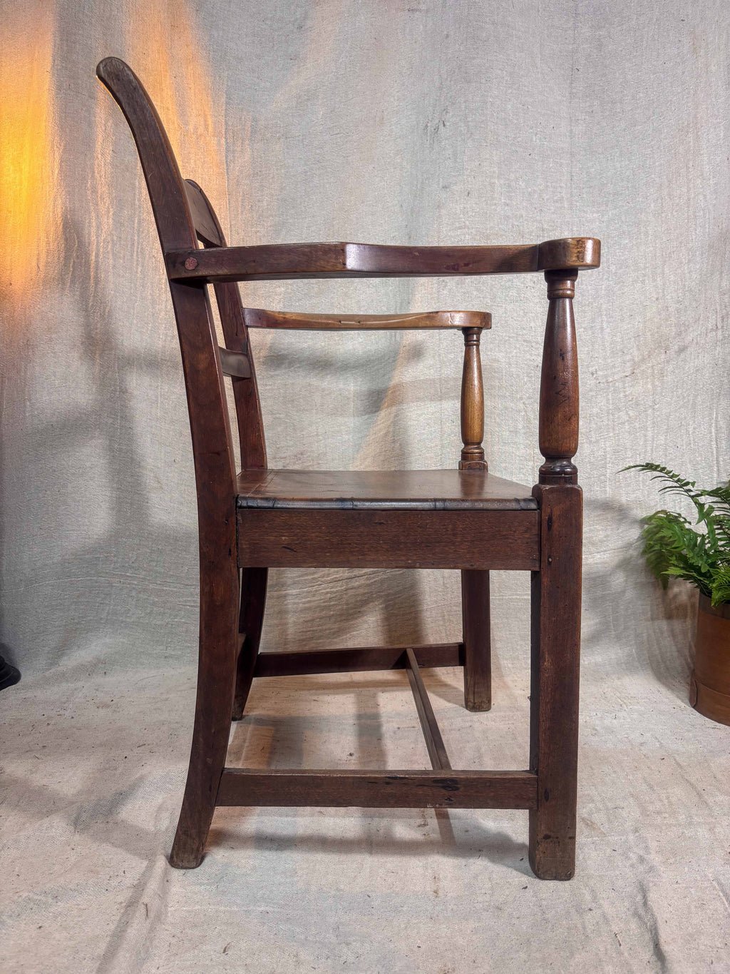 Wooden chair with armrests on a textured gray background