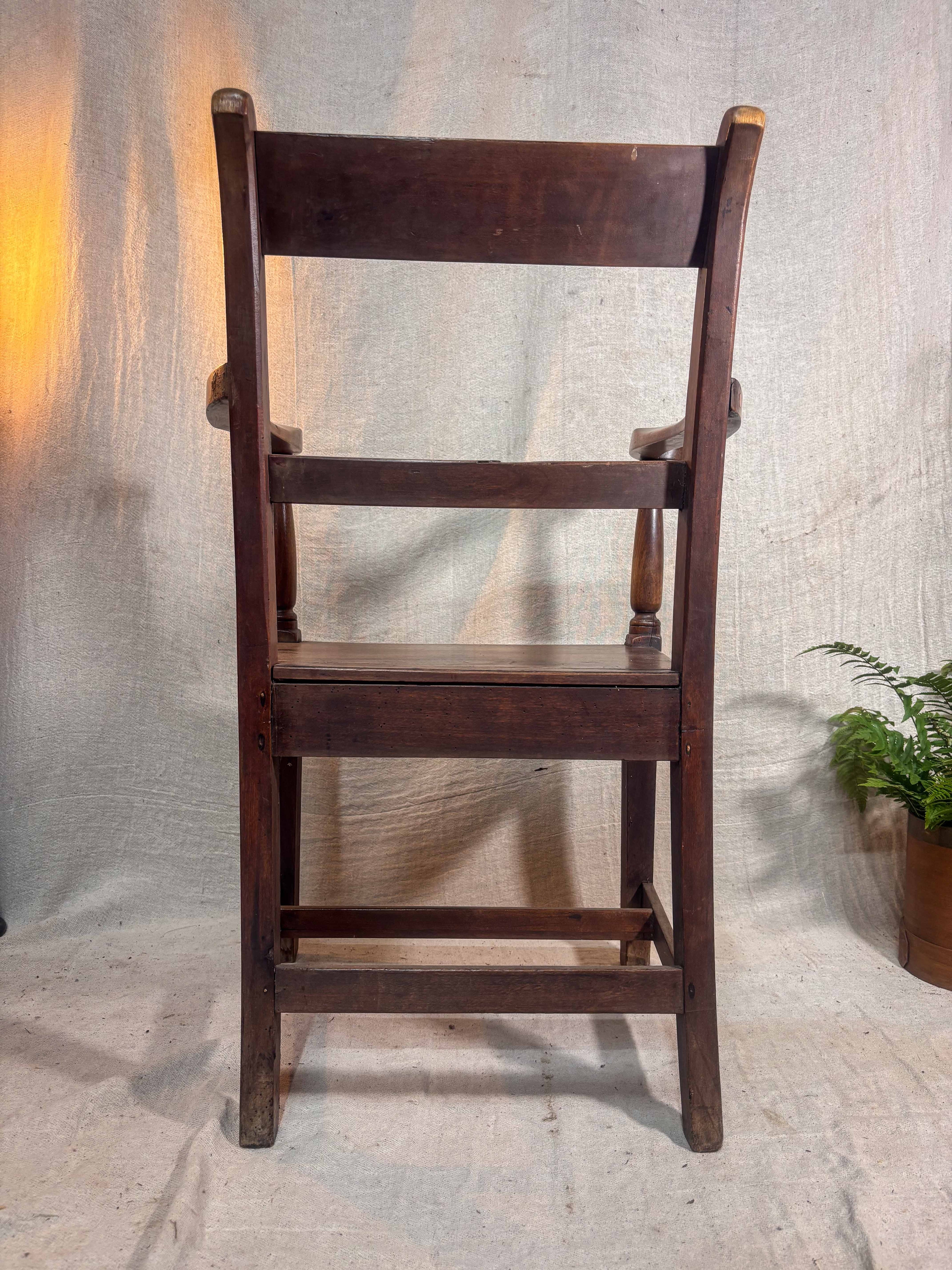 Wooden chair against a textured wall with a plant in the corner