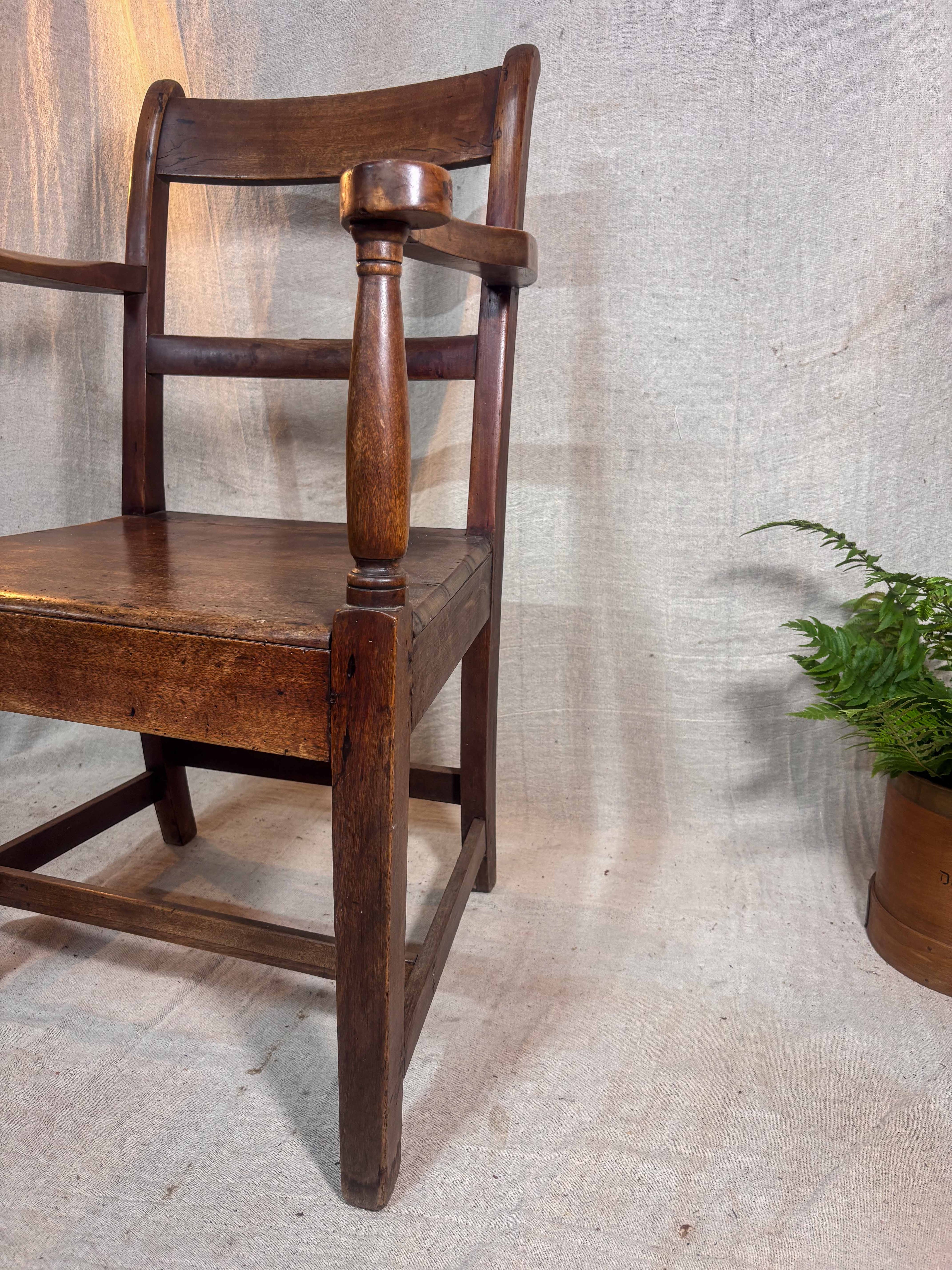 Wooden chair against a textured wall with a plant in the corner
