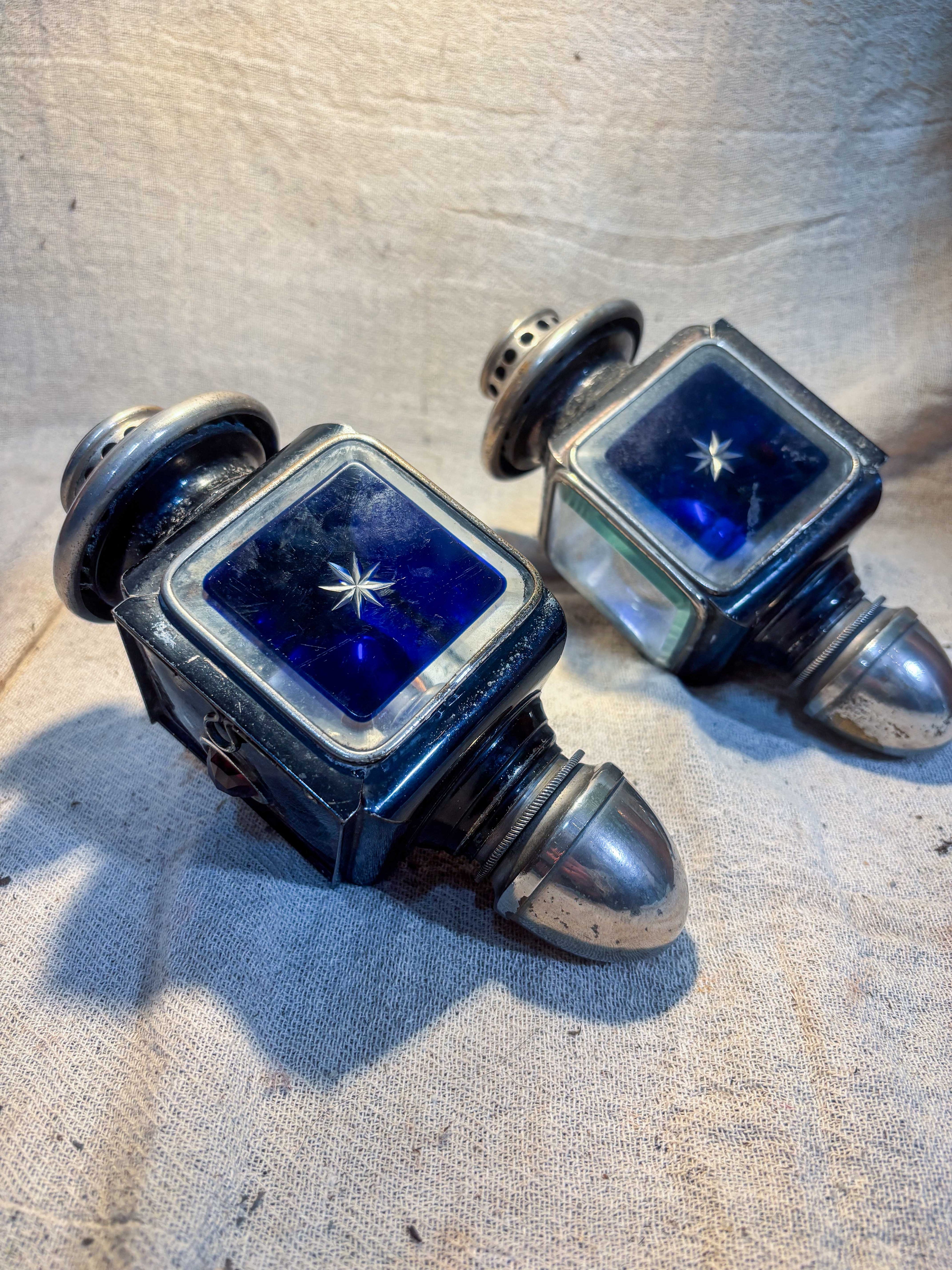 Pair of Carriage Lamps with blue glass on a textured surface