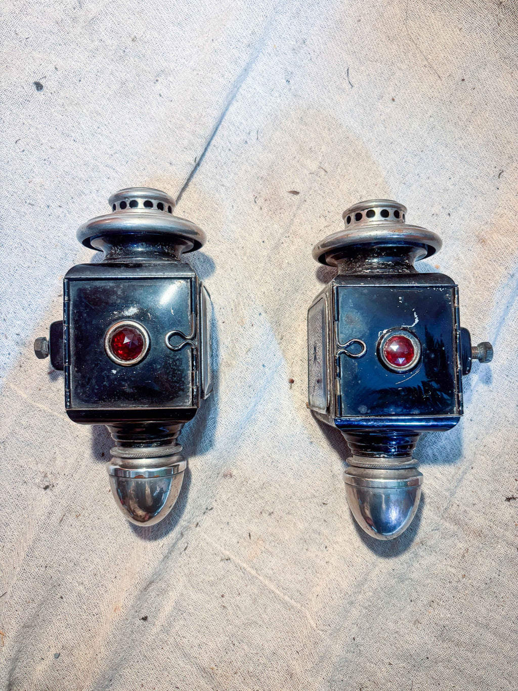 Two carriage lamps on a textured surface