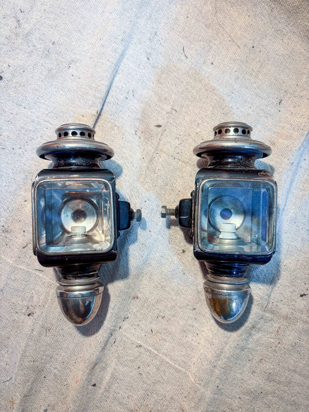 two small carriage lamps on cloth background