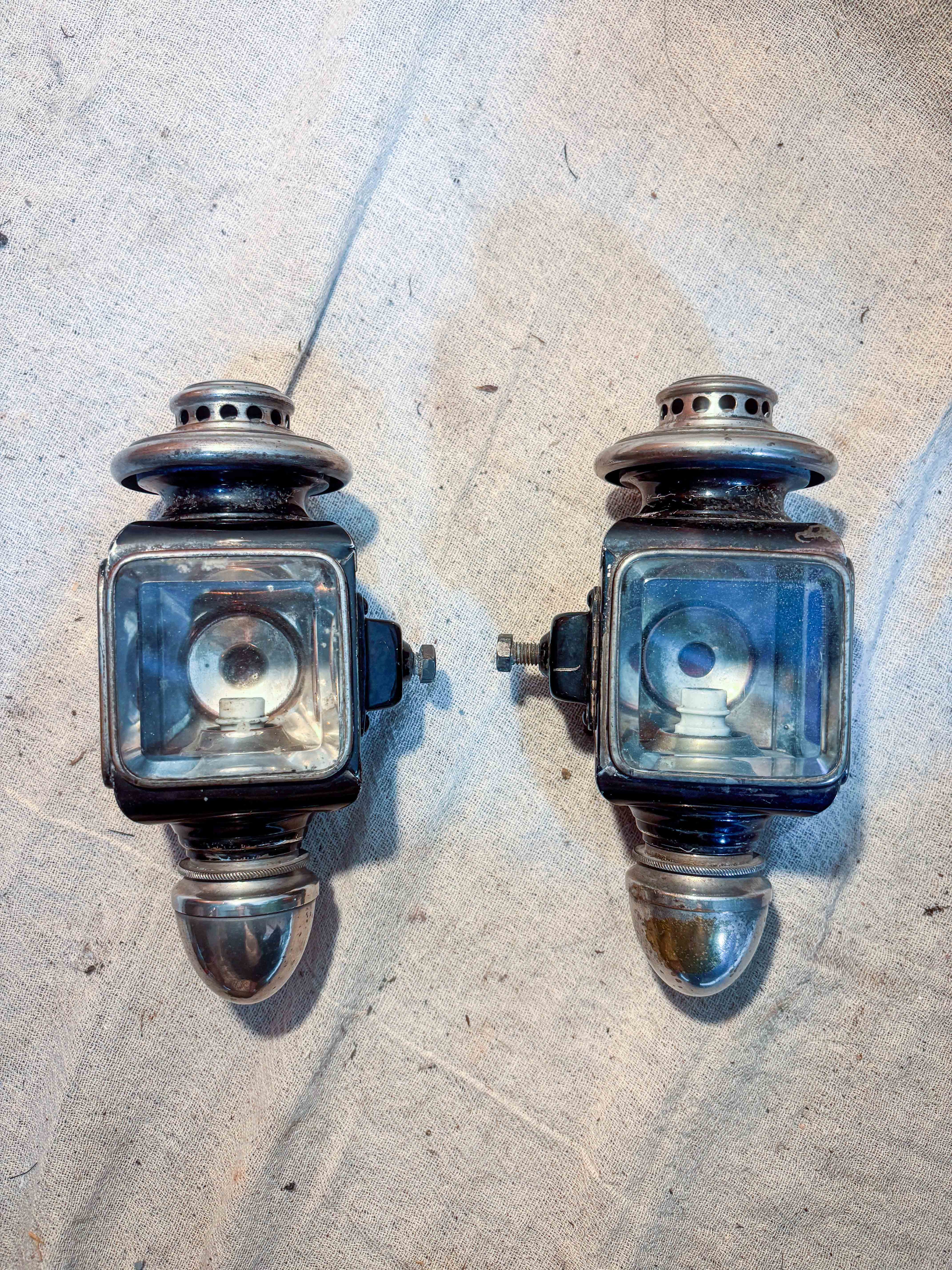 two small carriage lamps on cloth background