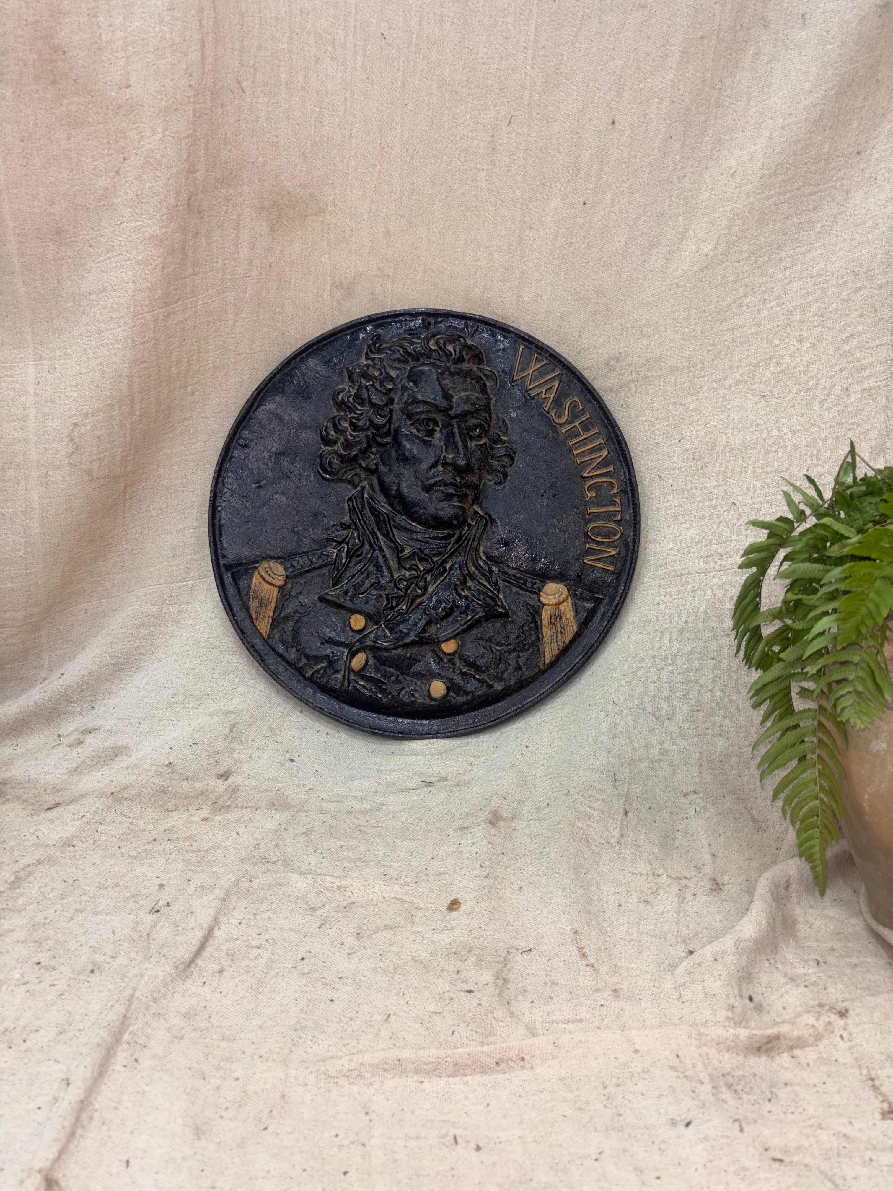 Decorative plaque with a portrait of a historical figure on a textured beige background