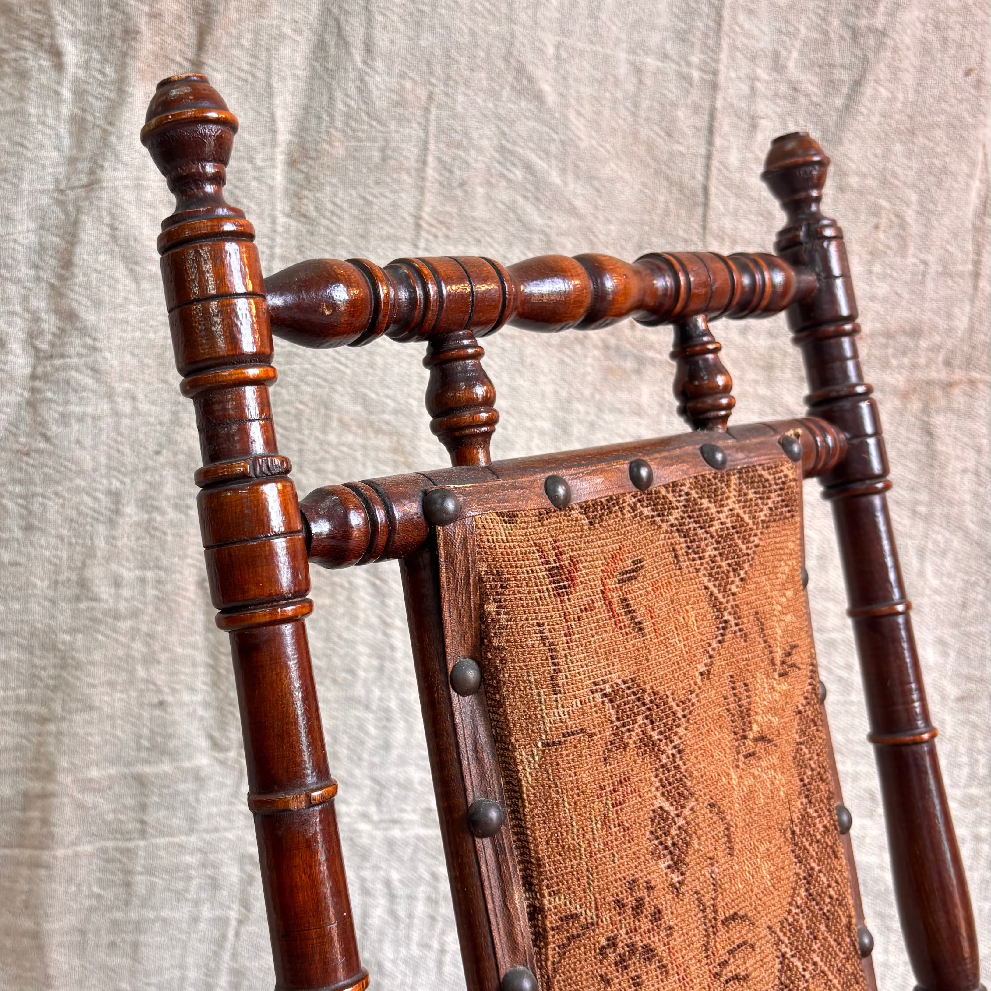Wooden chair with intricate design against a textured beige background