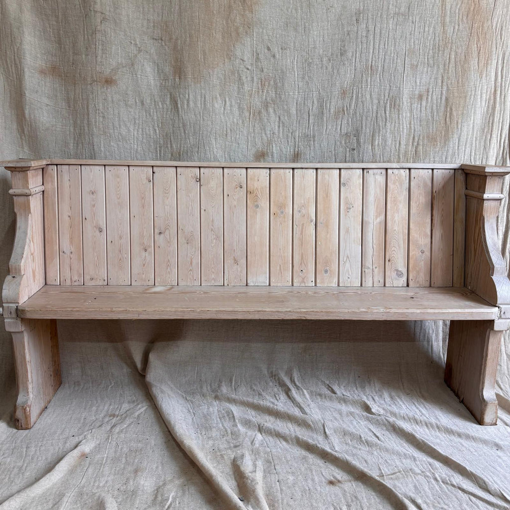 Wooden bench against a textured wall