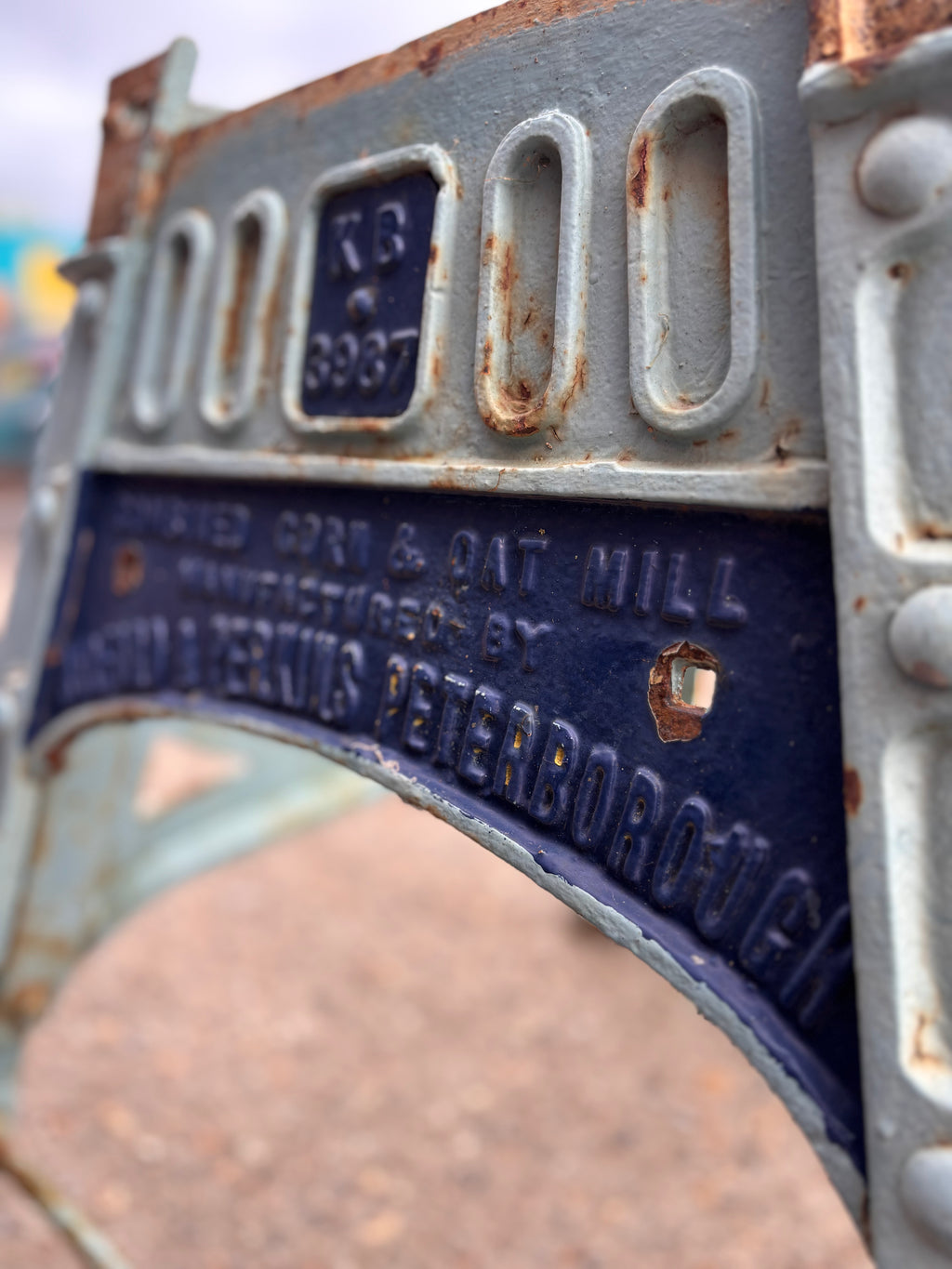 Rust-covered metal machine base with engraved text and numbers