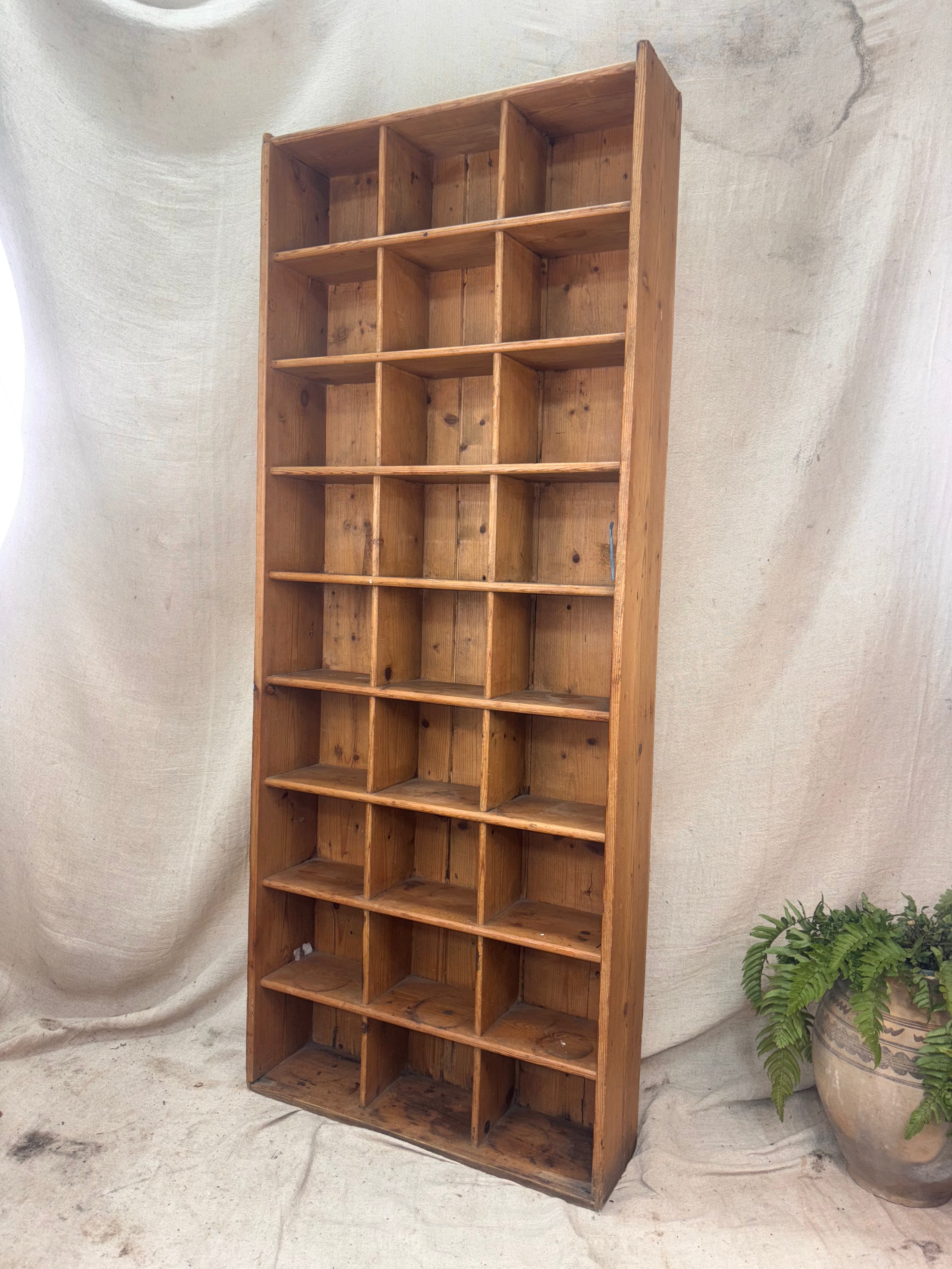 Wooden bookshelf with multiple shelves against a plain background