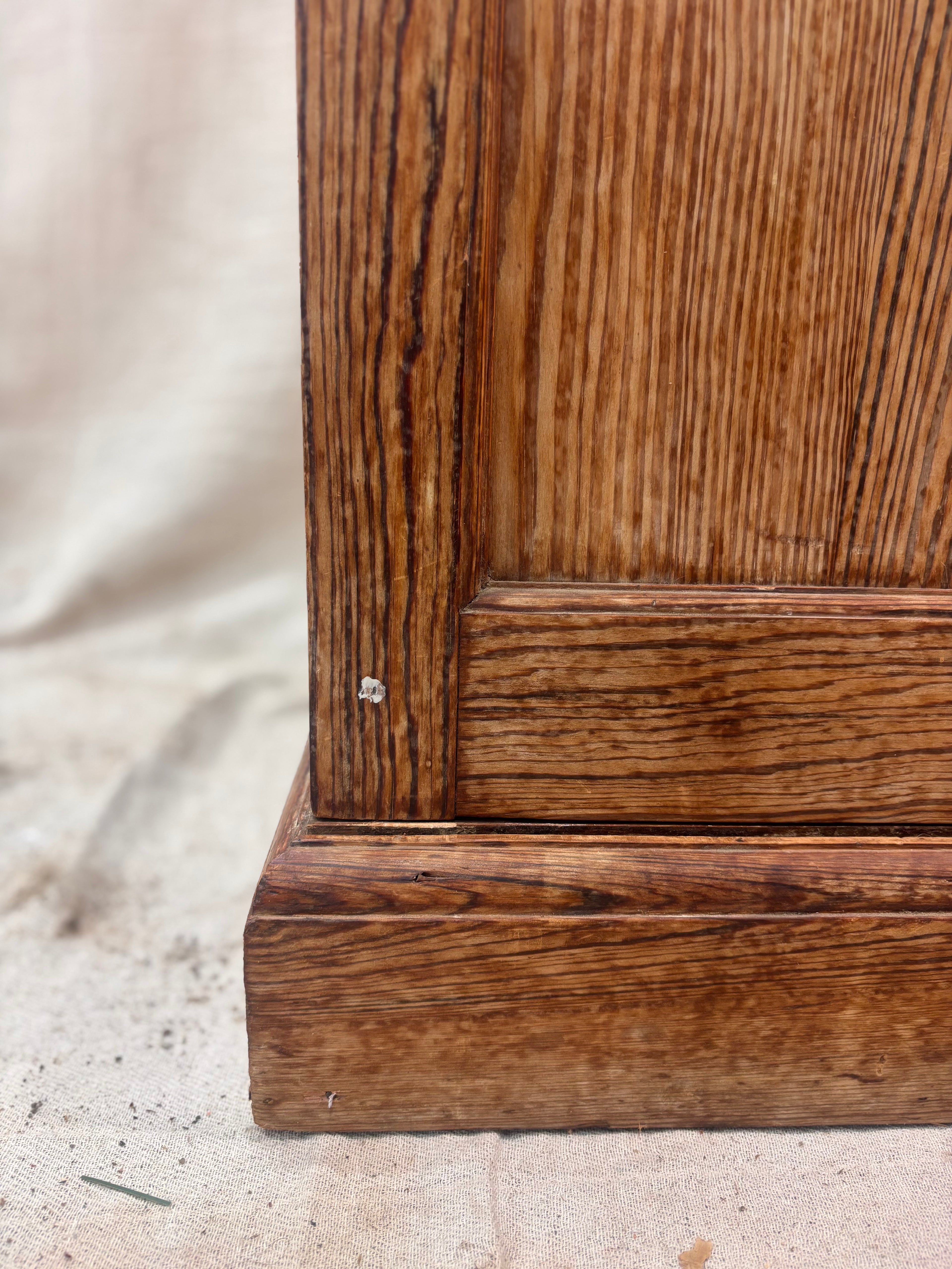 Close-up of a wooden cabinet corner with visible grain and texture.