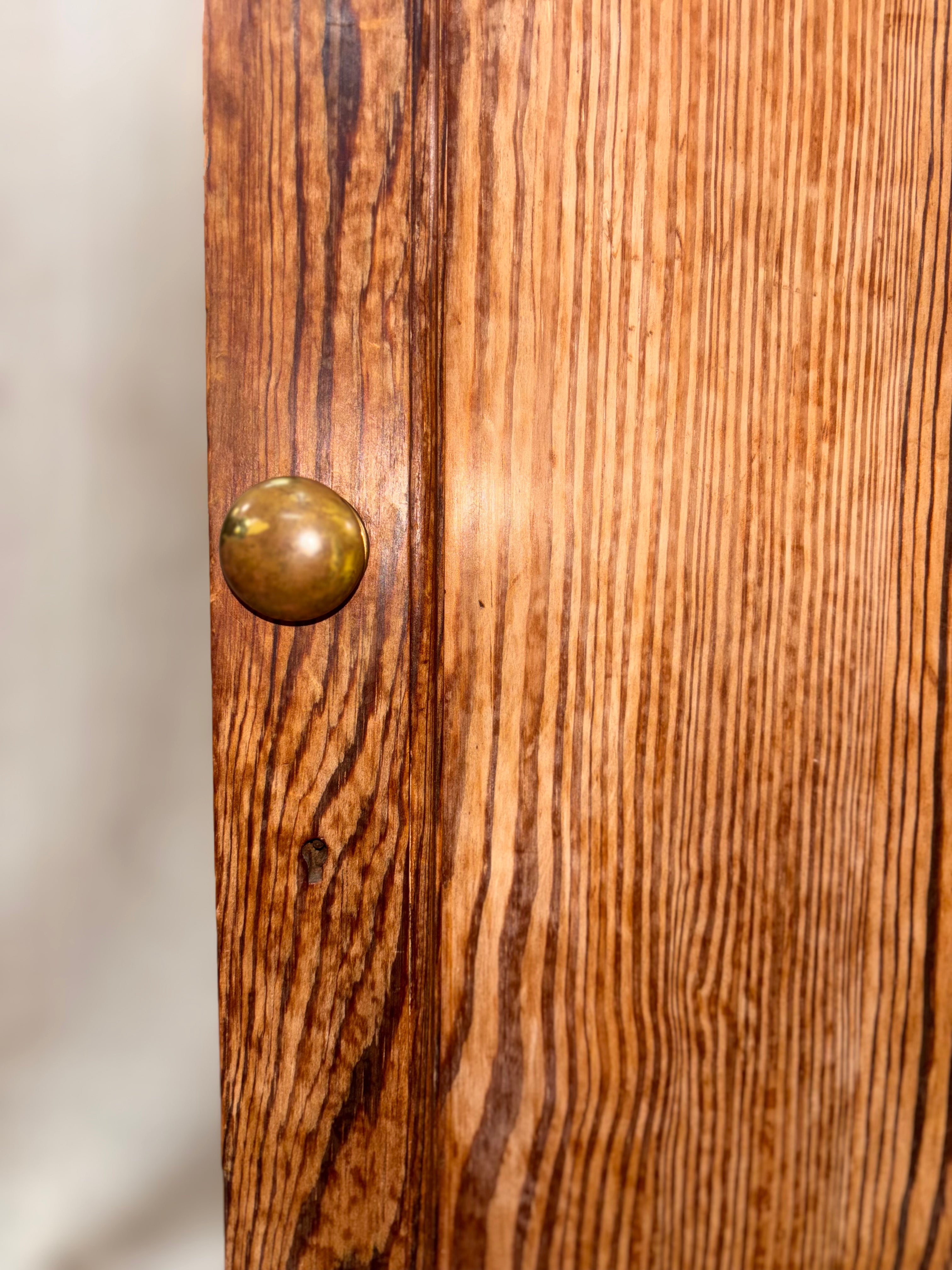 Close-up of a wooden cabinet with a brass knob