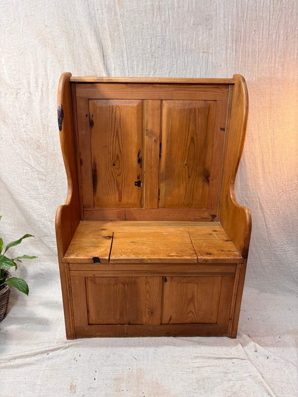 Wooden bench with backrest and storage compartments on a light background