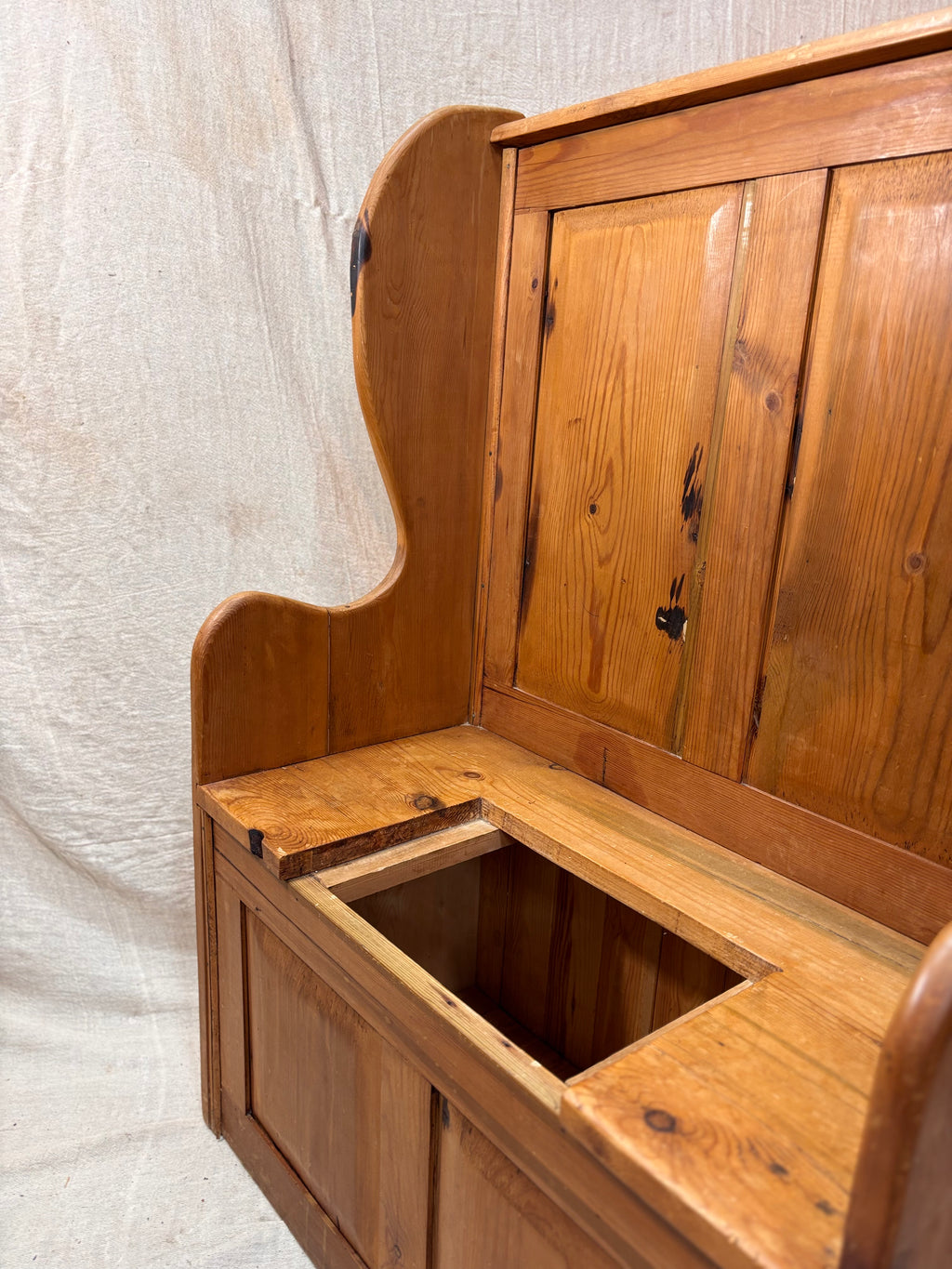 Wooden bench with storage compartment on a textured white background
