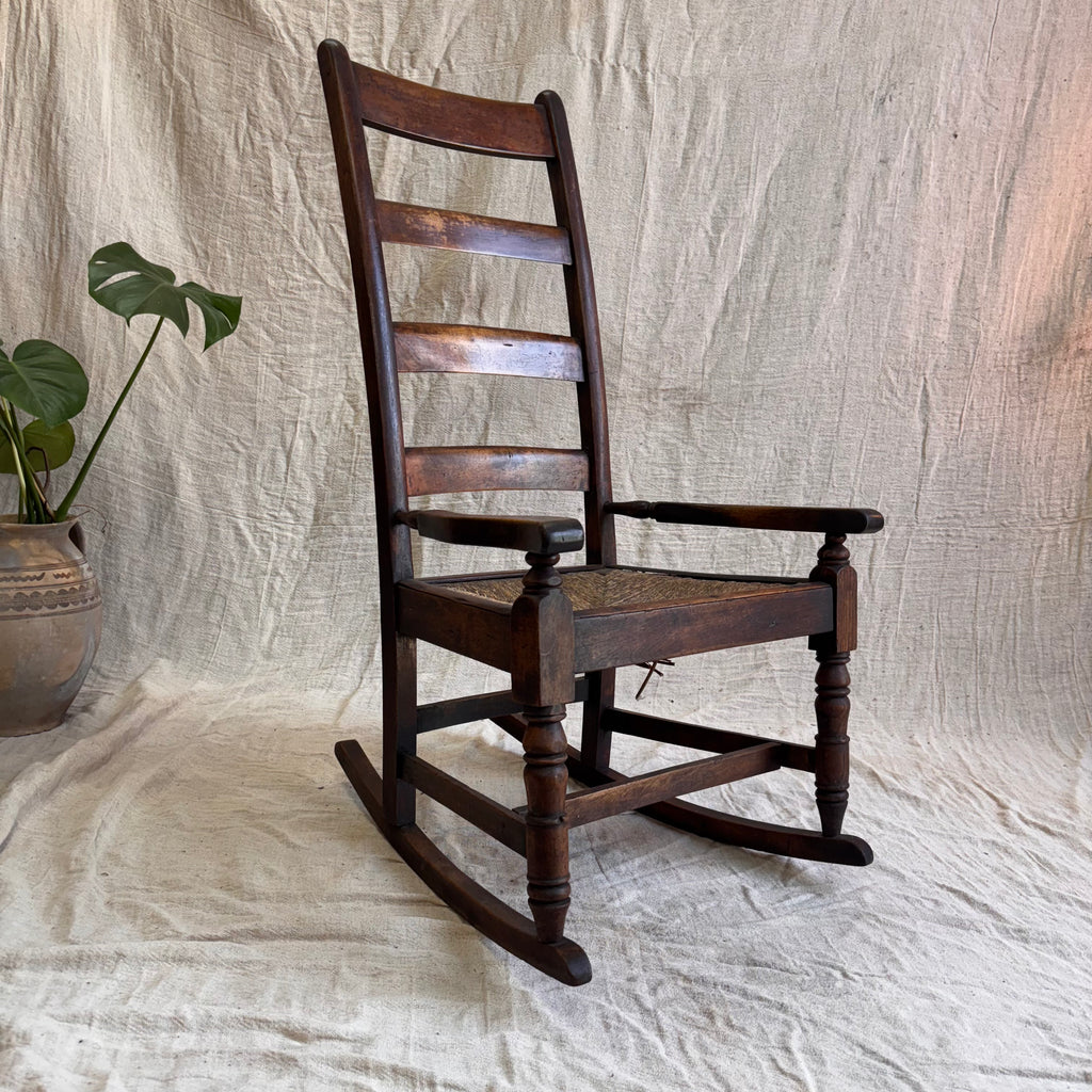 A wooden rocking chair on a cream background