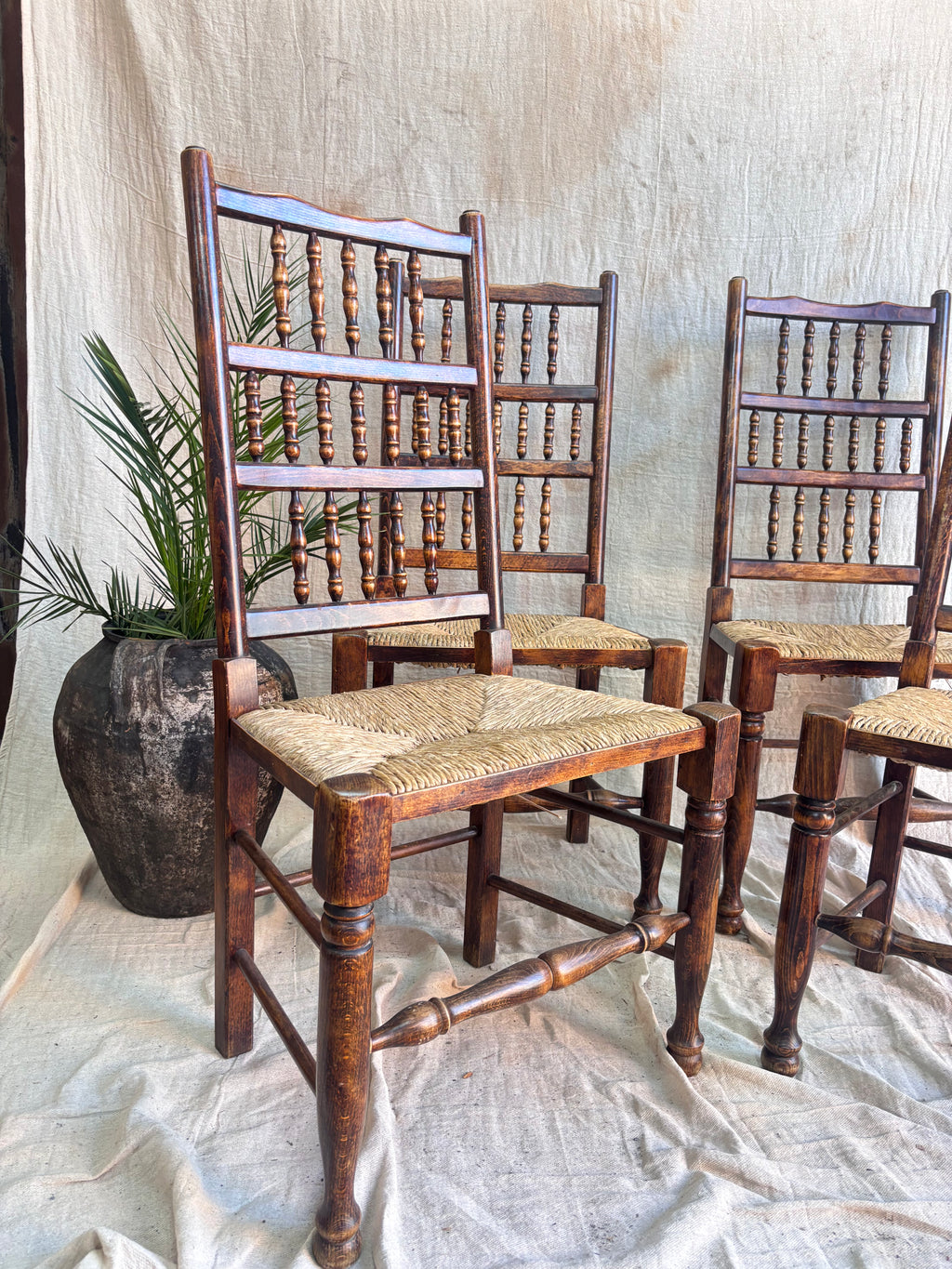 Wooden chairs with woven seats on a textured surface