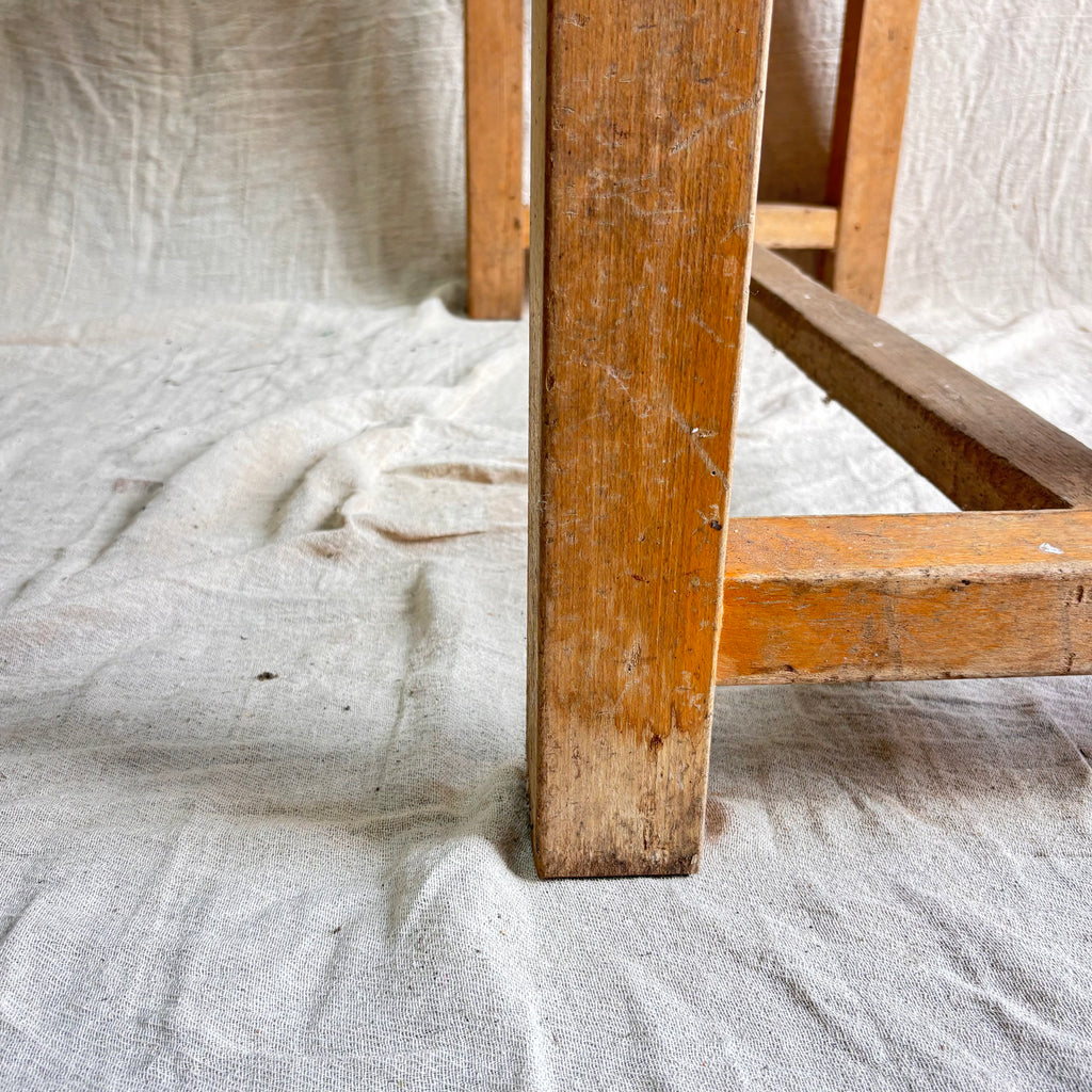 Close-up of a wooden table leg on a textured fabric background