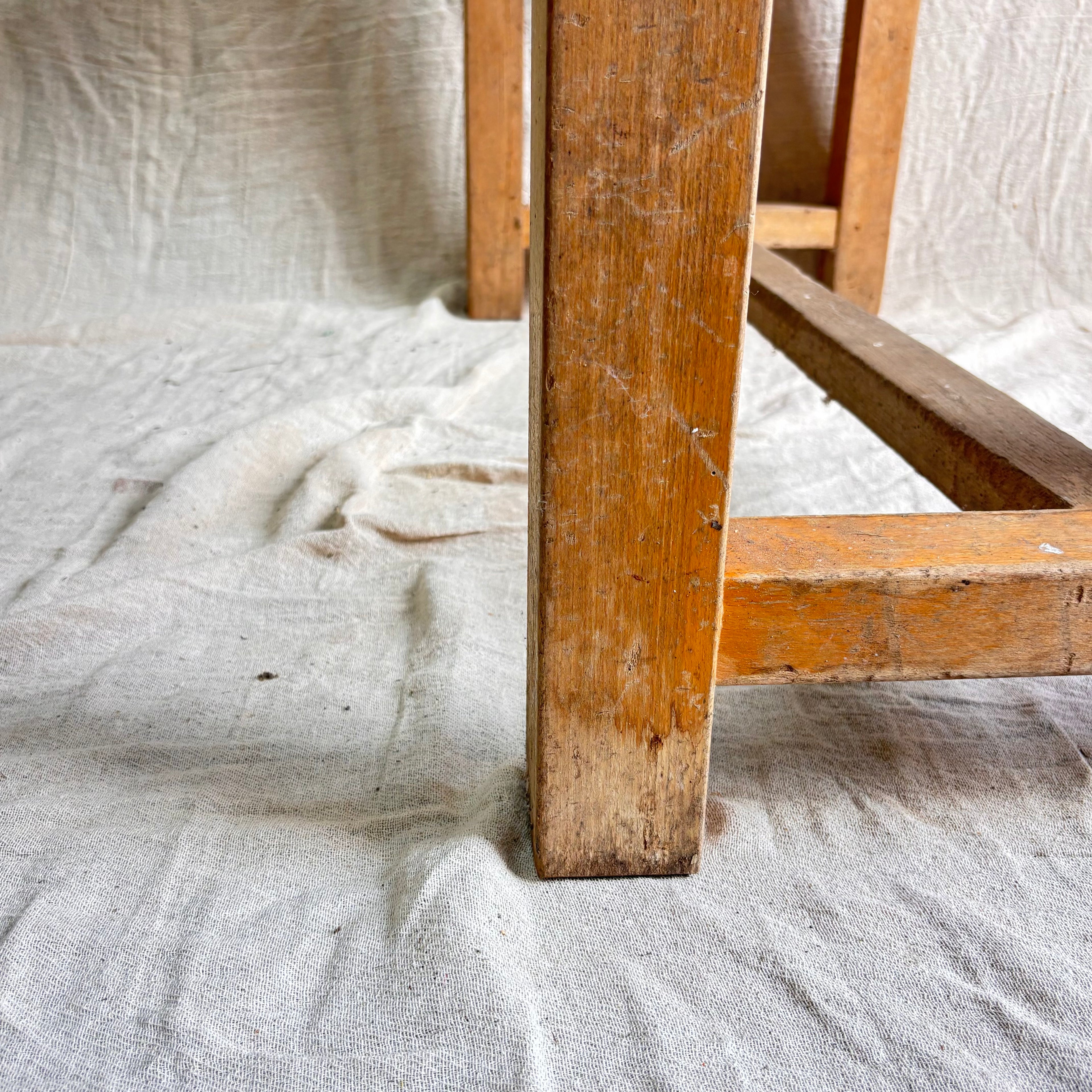 Close-up of a wooden table leg on a textured fabric background