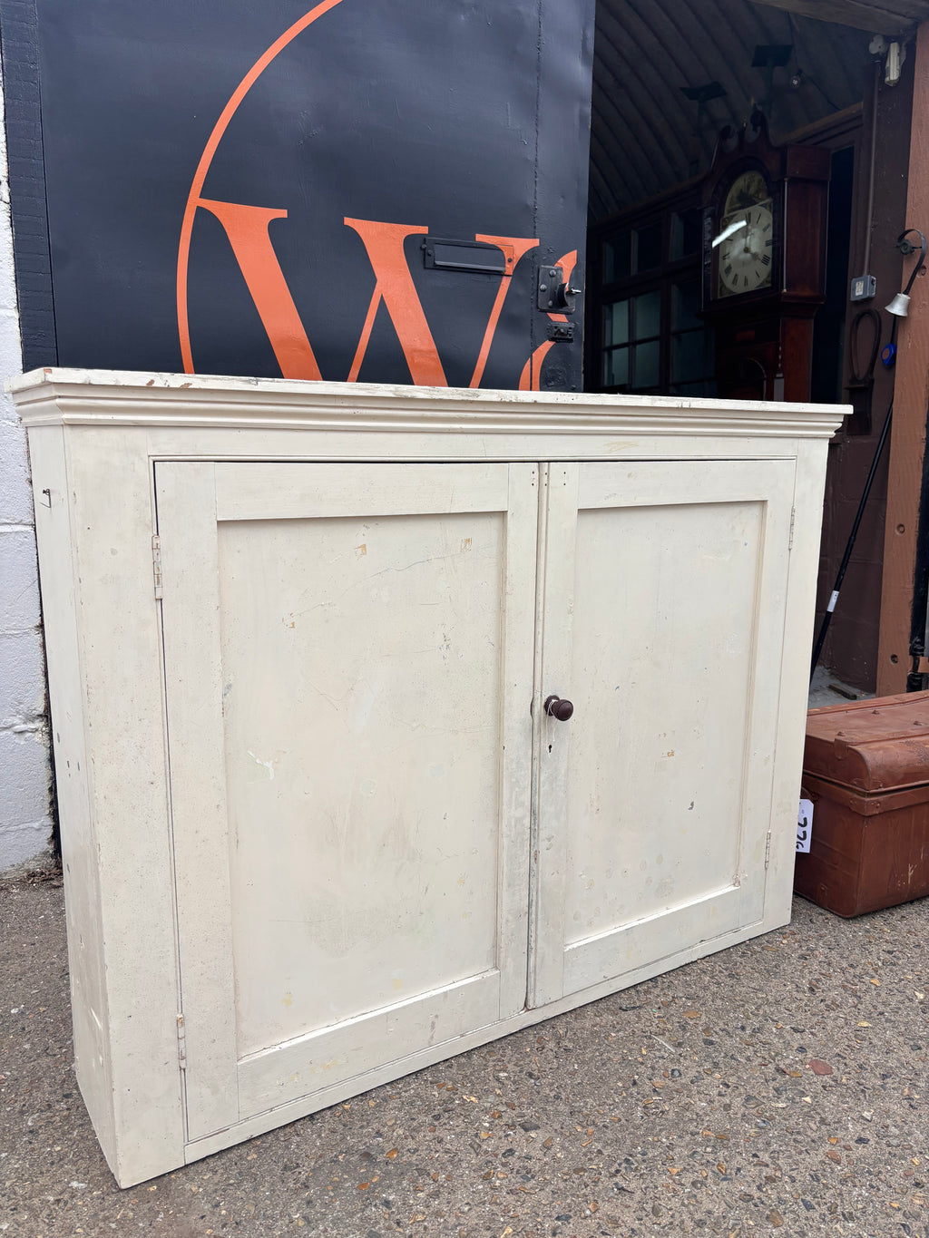 Two wooden cabinet doors on a concrete surface with a visible brand logo in the background.