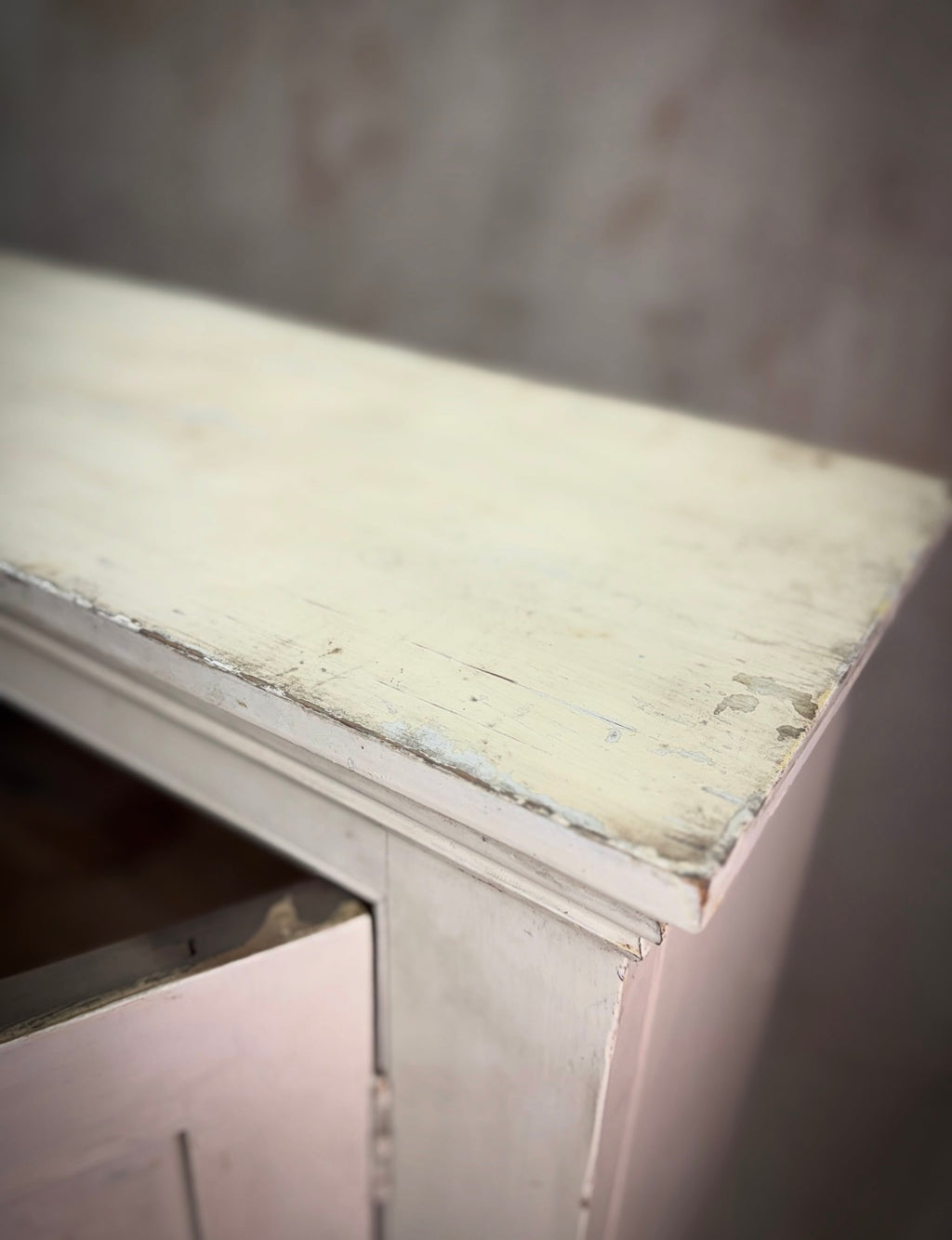 Close-up of a worn-out wooden surface with peeling paint.