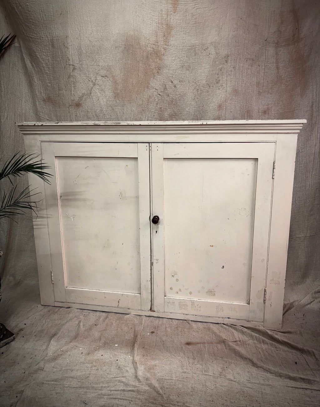 Vintage-style wooden cabinet with two doors on a textured gray background