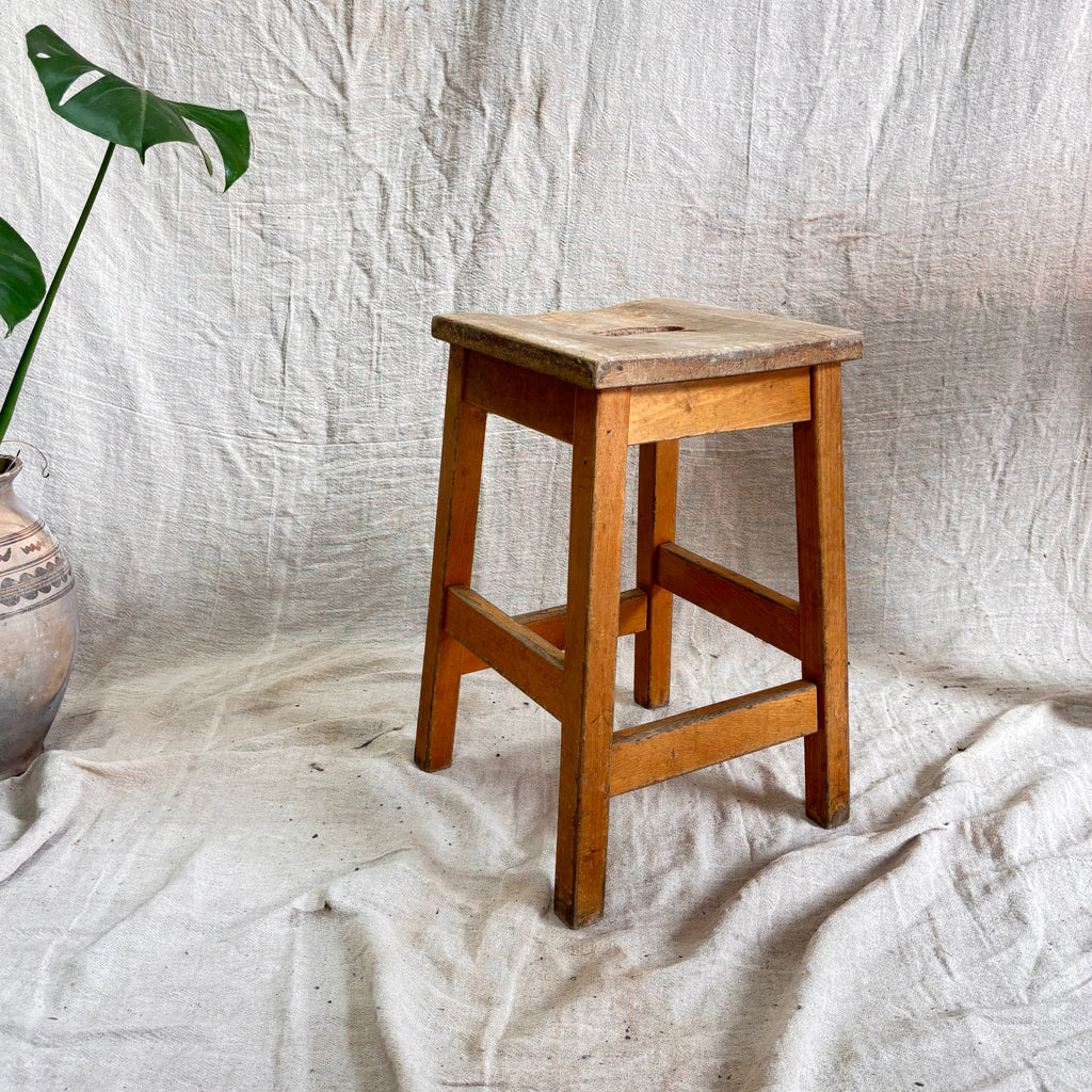 Wooden stool on a textured white fabric background
