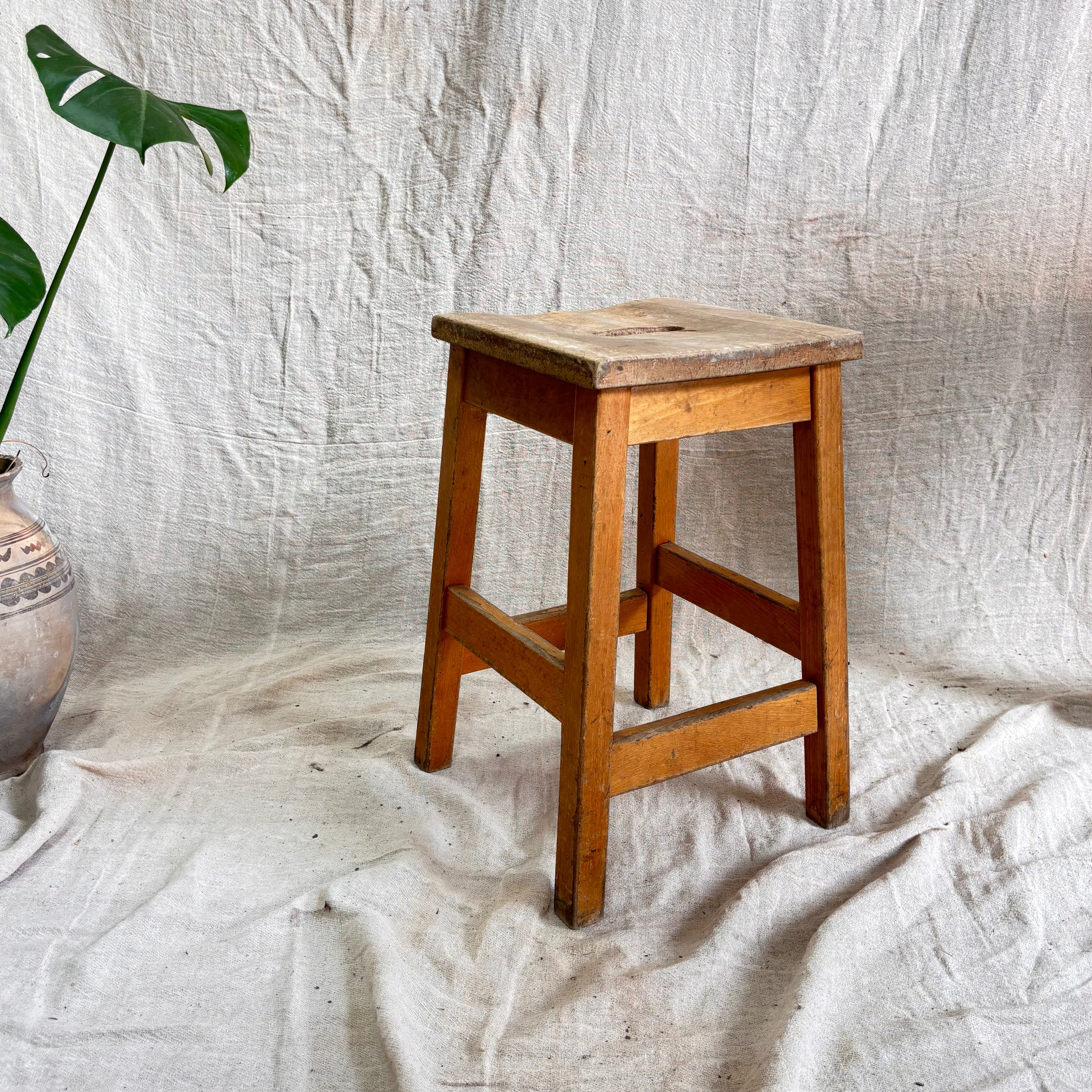 Wooden stool on a textured white fabric background
