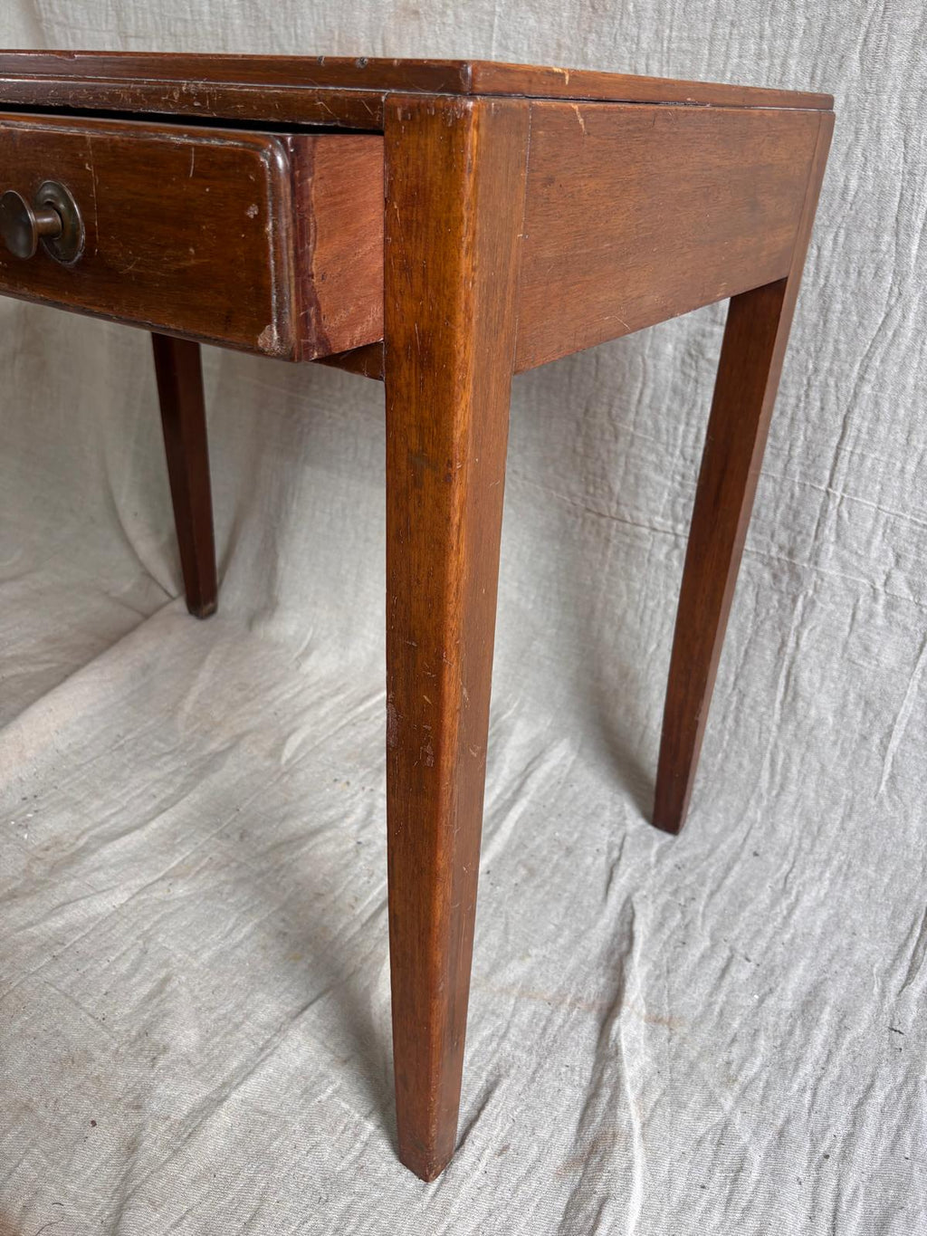 Wooden desk with a single drawer on a textured white background