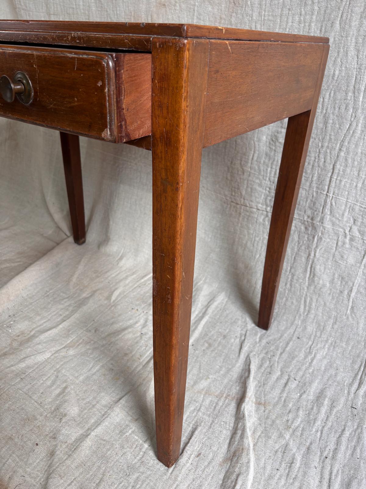 Wooden desk with a single drawer on a textured white background