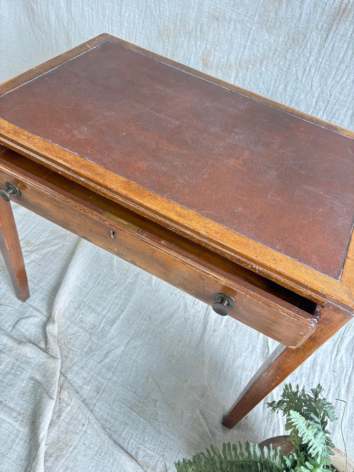 Wooden desk with leather surface on a textured white background