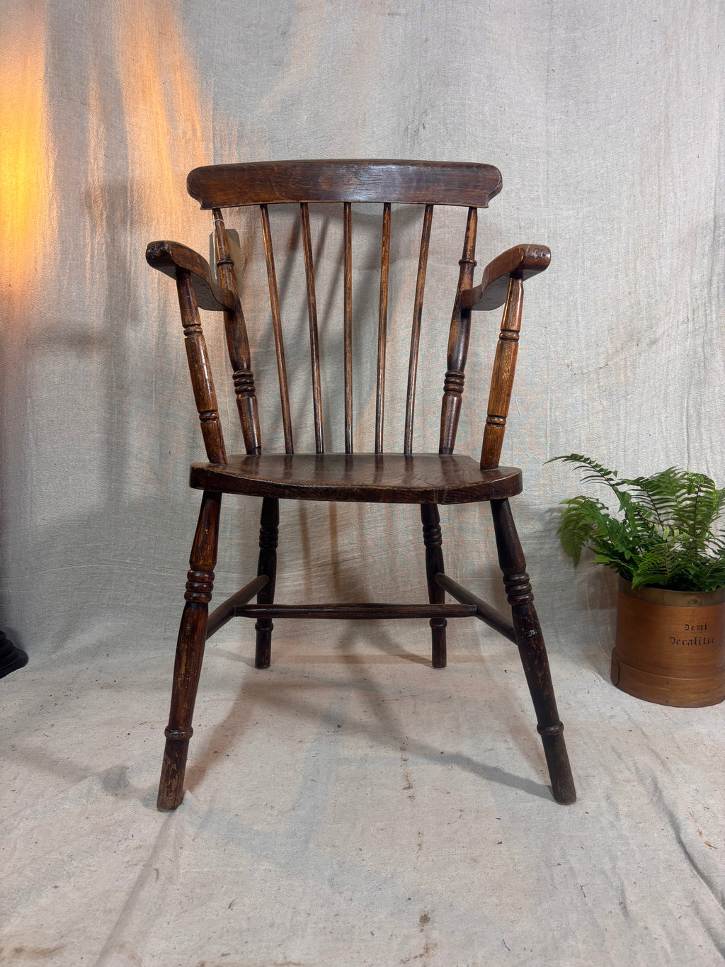 Wooden chair with a plant on a textured floor