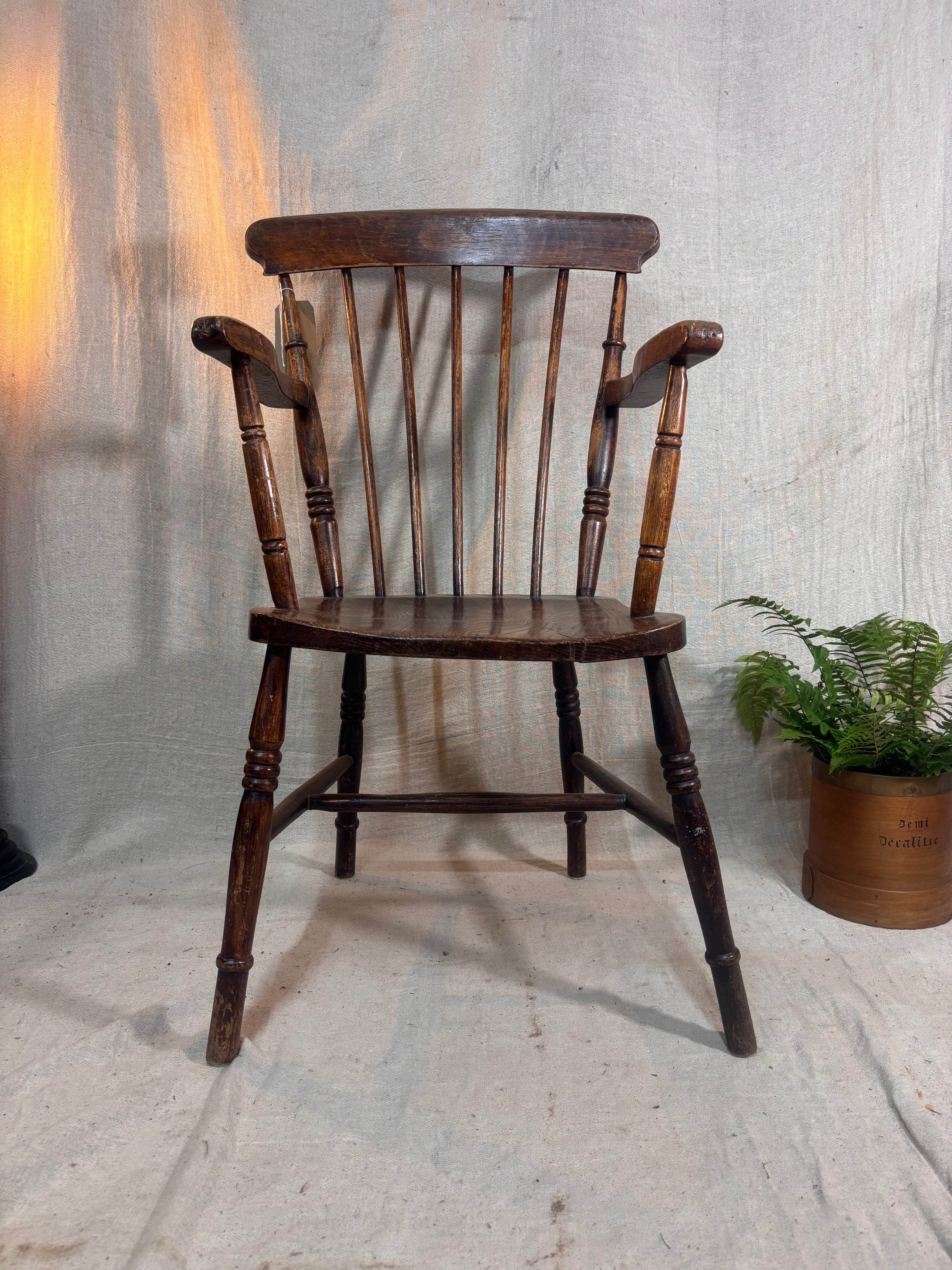 Wooden chair with a plant on a textured floor