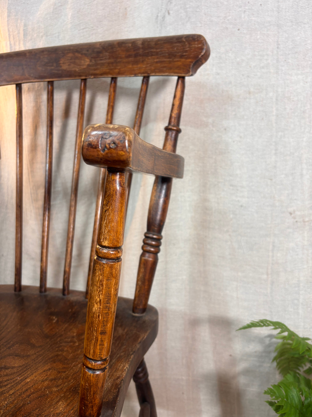 Close-up of a wooden chair with a textured wall background