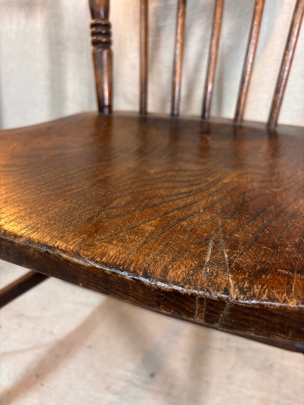 Close-up of a wooden chair seat with visible grain and wear.