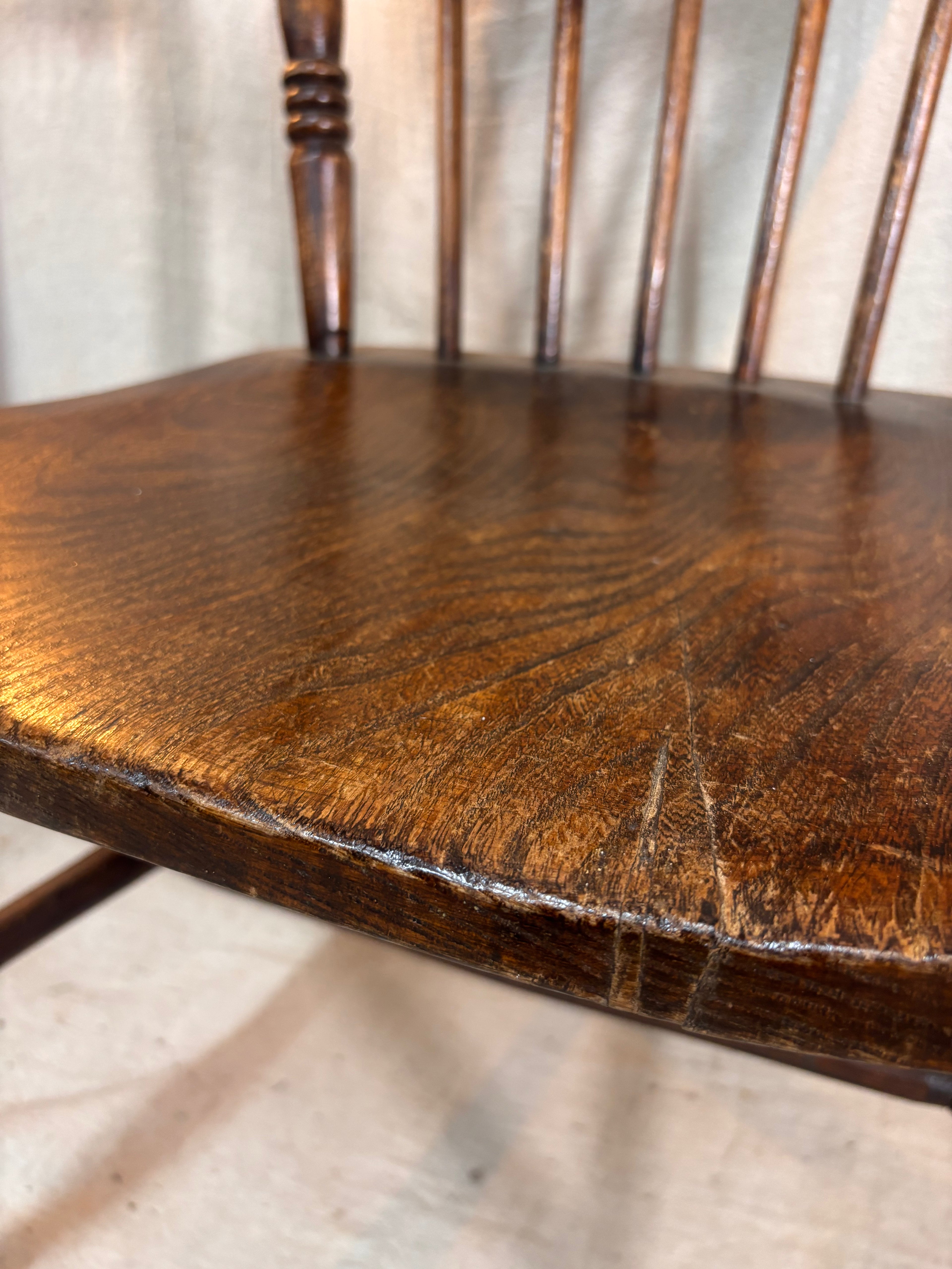 Close-up of a wooden chair seat with visible grain and wear.