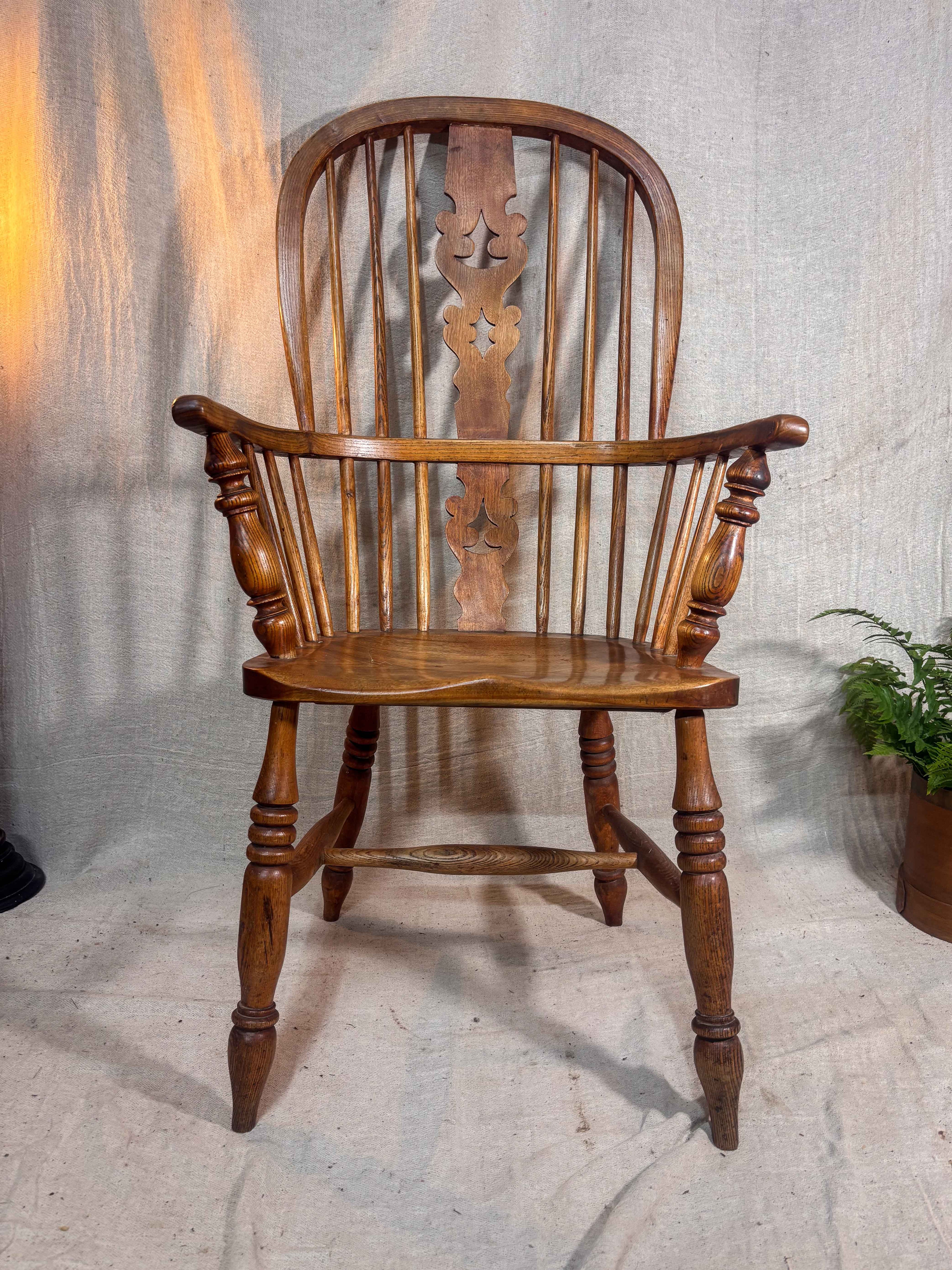 Wooden armchair with intricate design on a textured wall background