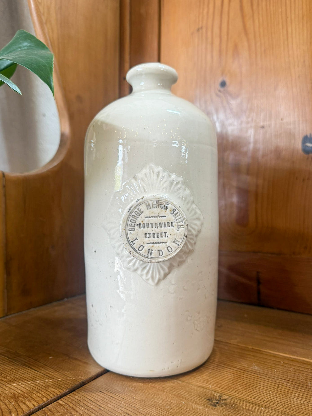 White ceramic hot water bottle with decorative label on a wooden surface