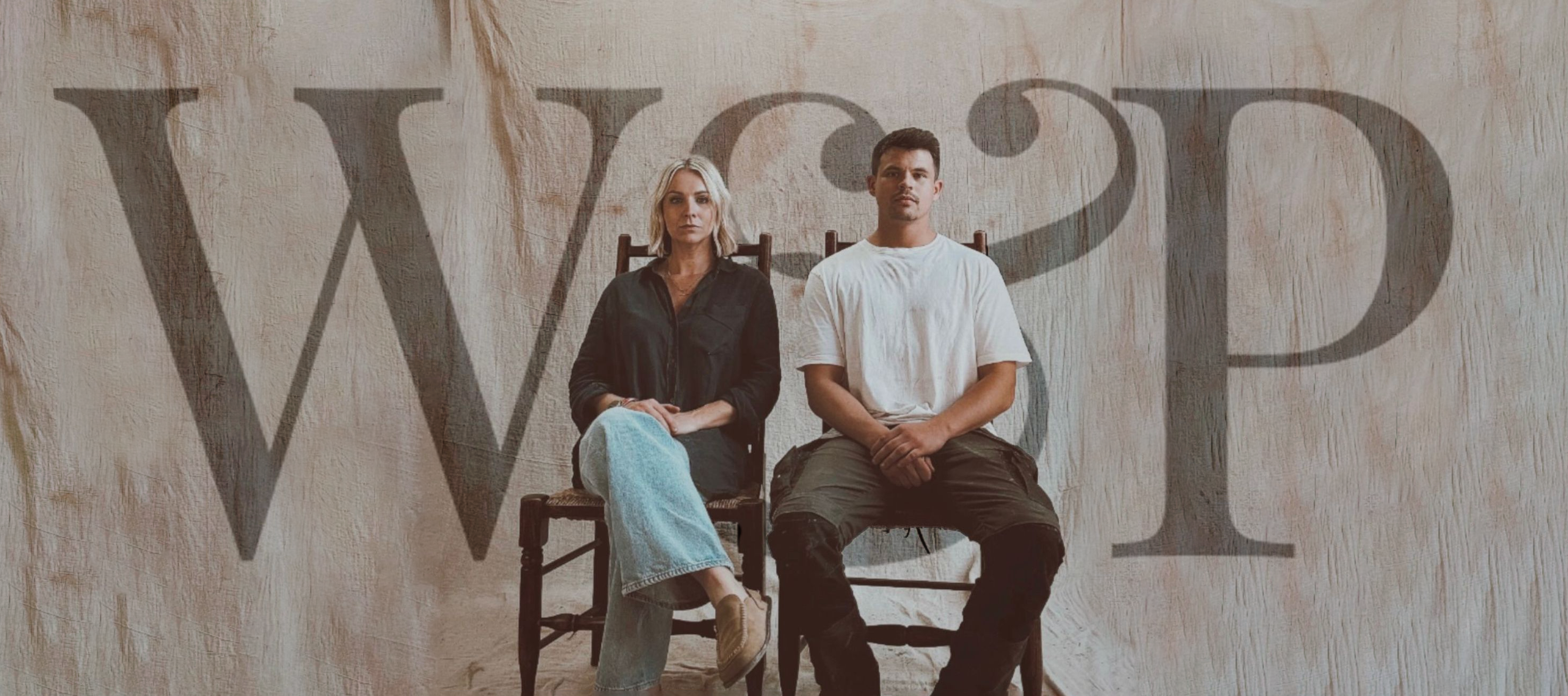 Two people sitting on chairs with a large 'W&P' logo in the background