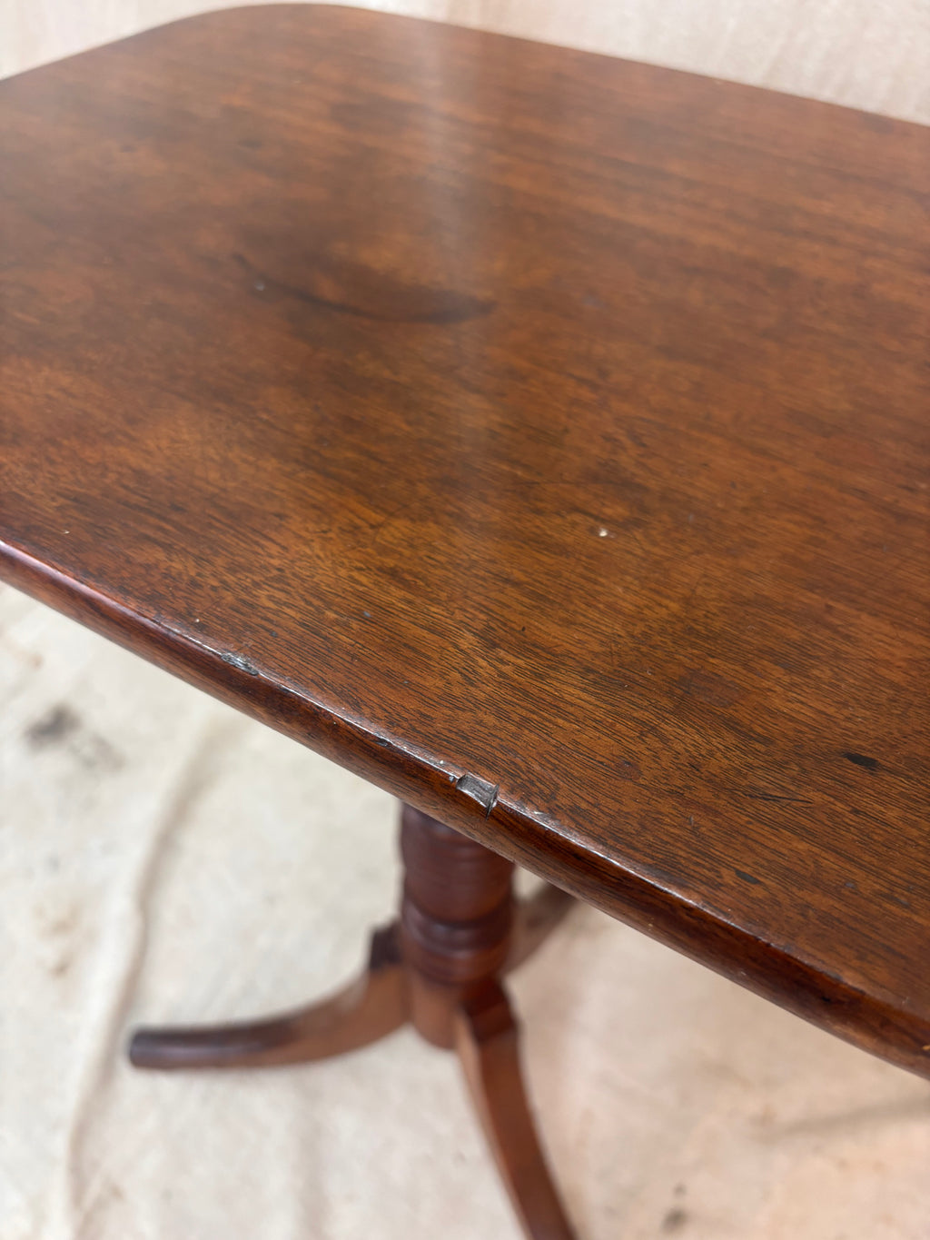 Wooden table with a worn surface on a textured floor