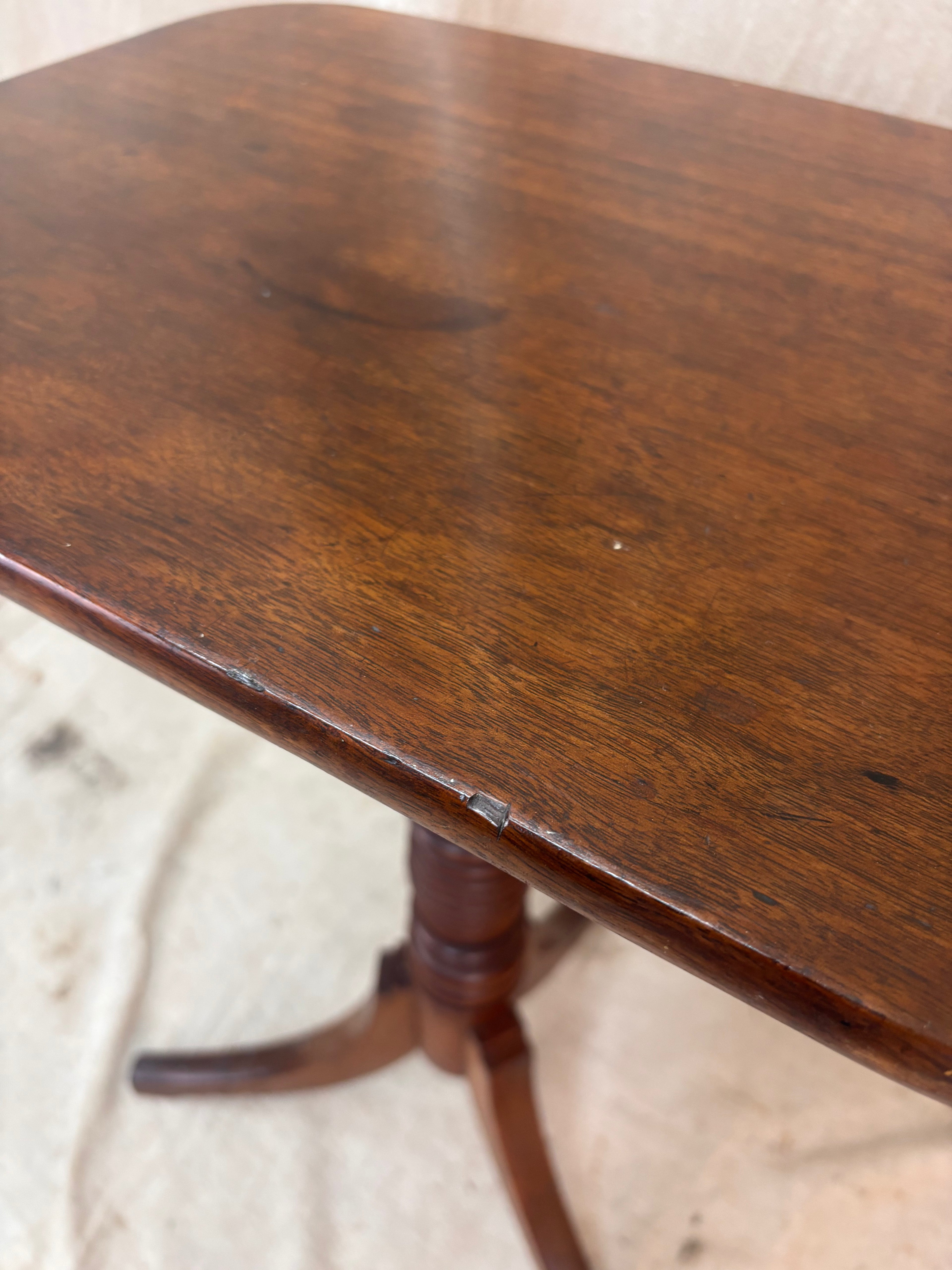 Wooden table with a worn surface on a textured floor