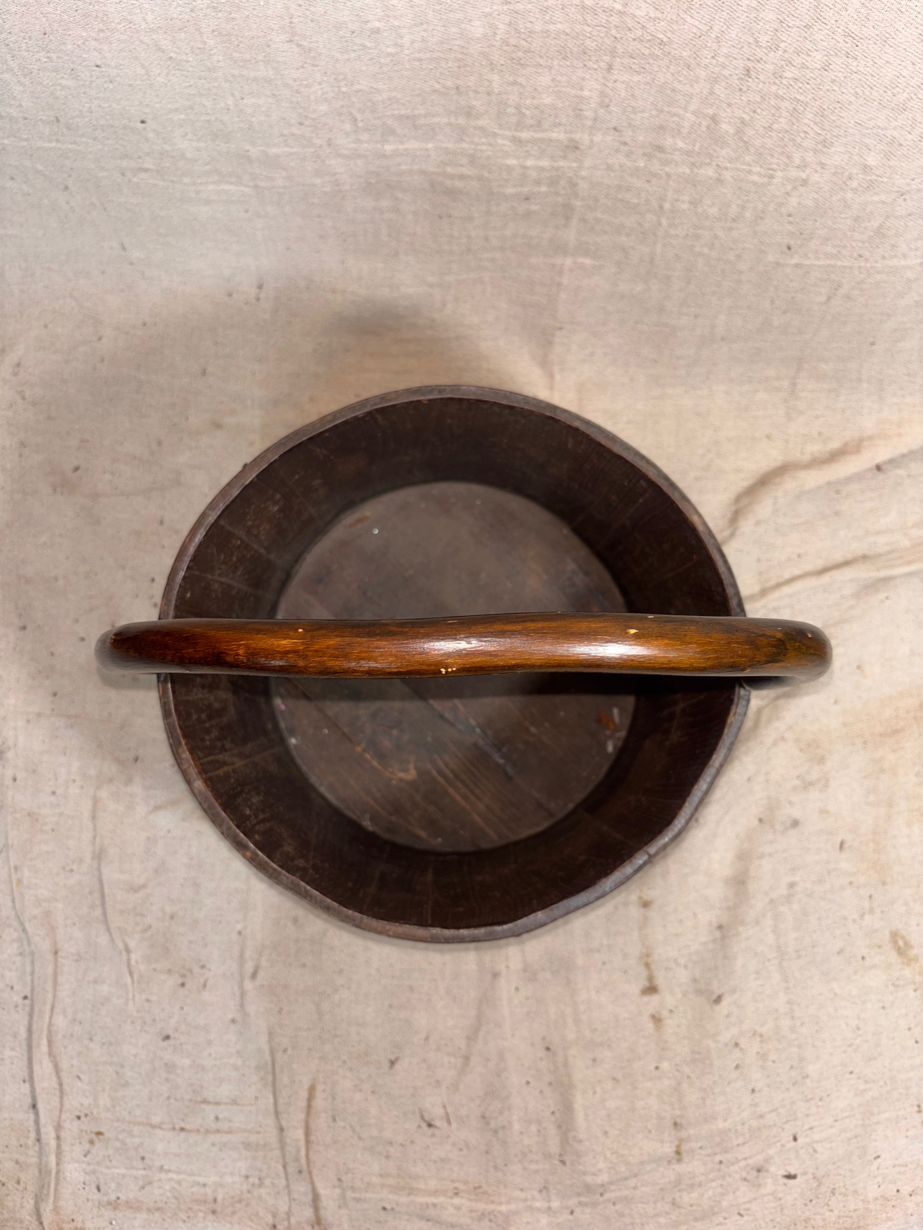 Wooden handle on a wooden bucket against a textured cloth background