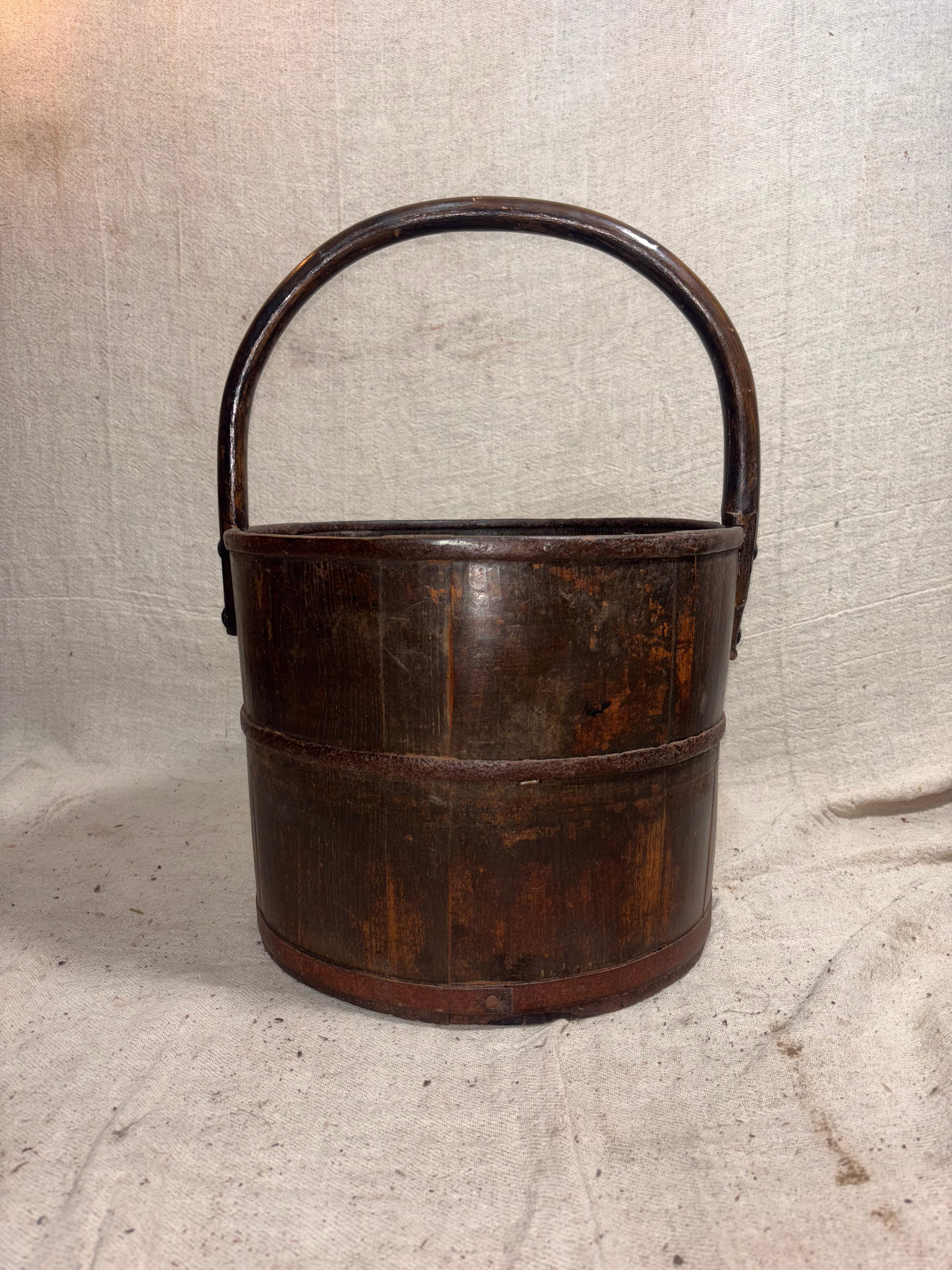 Wooden bucket with a handle on a textured beige background