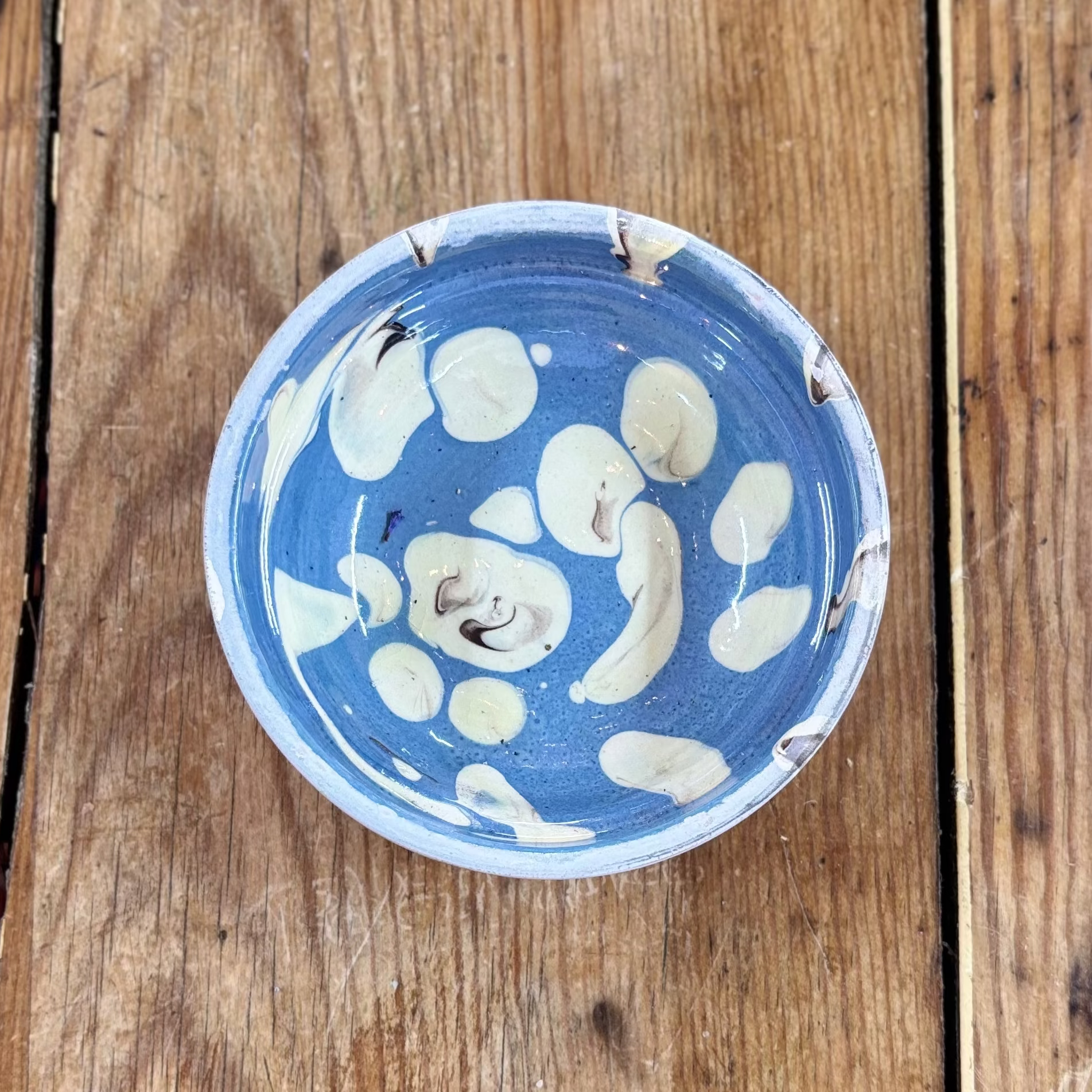 Blue ceramic bowl with white floral patterns on a wooden surface