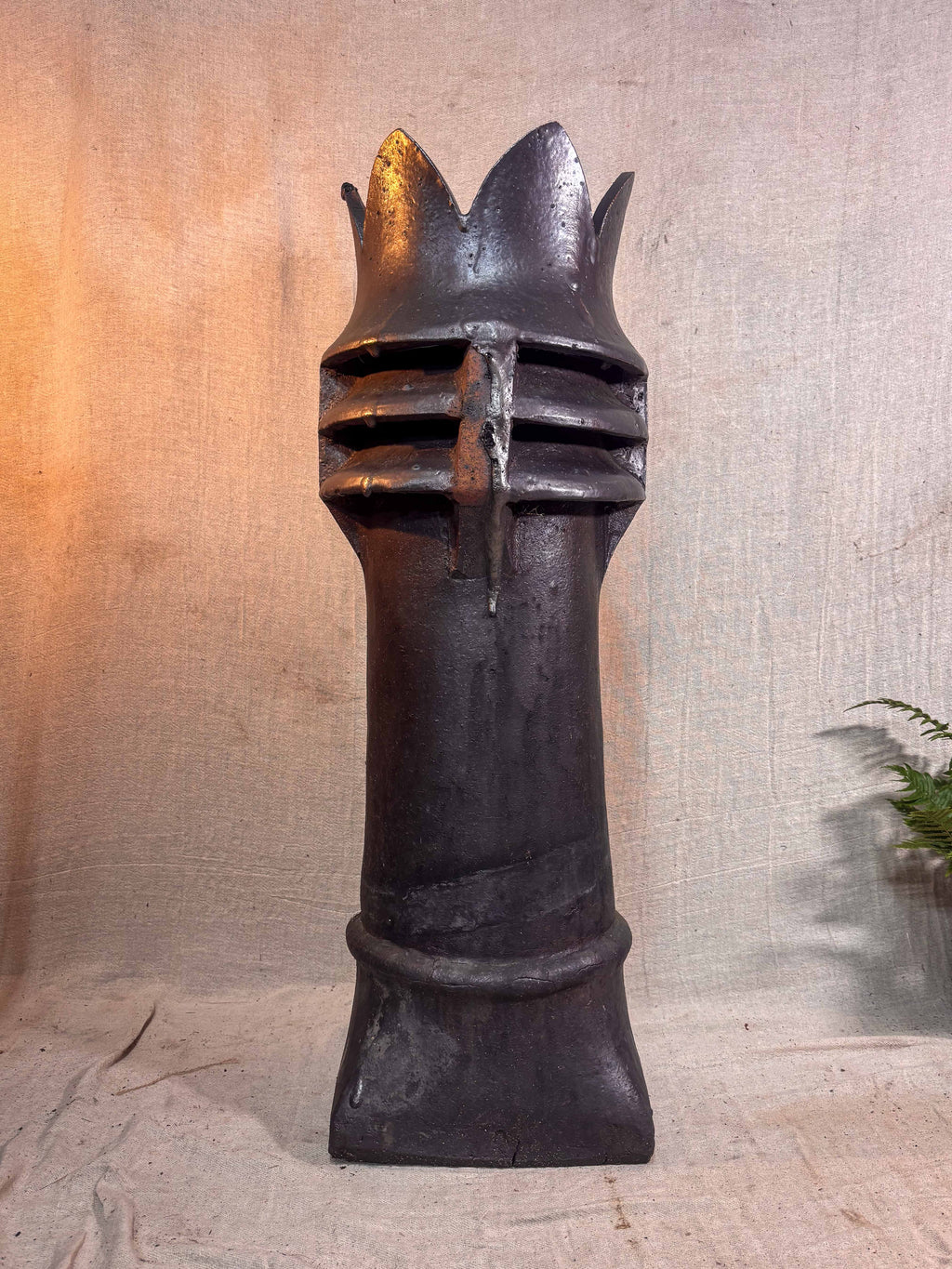 brown glazed chimney pot on a textured surface