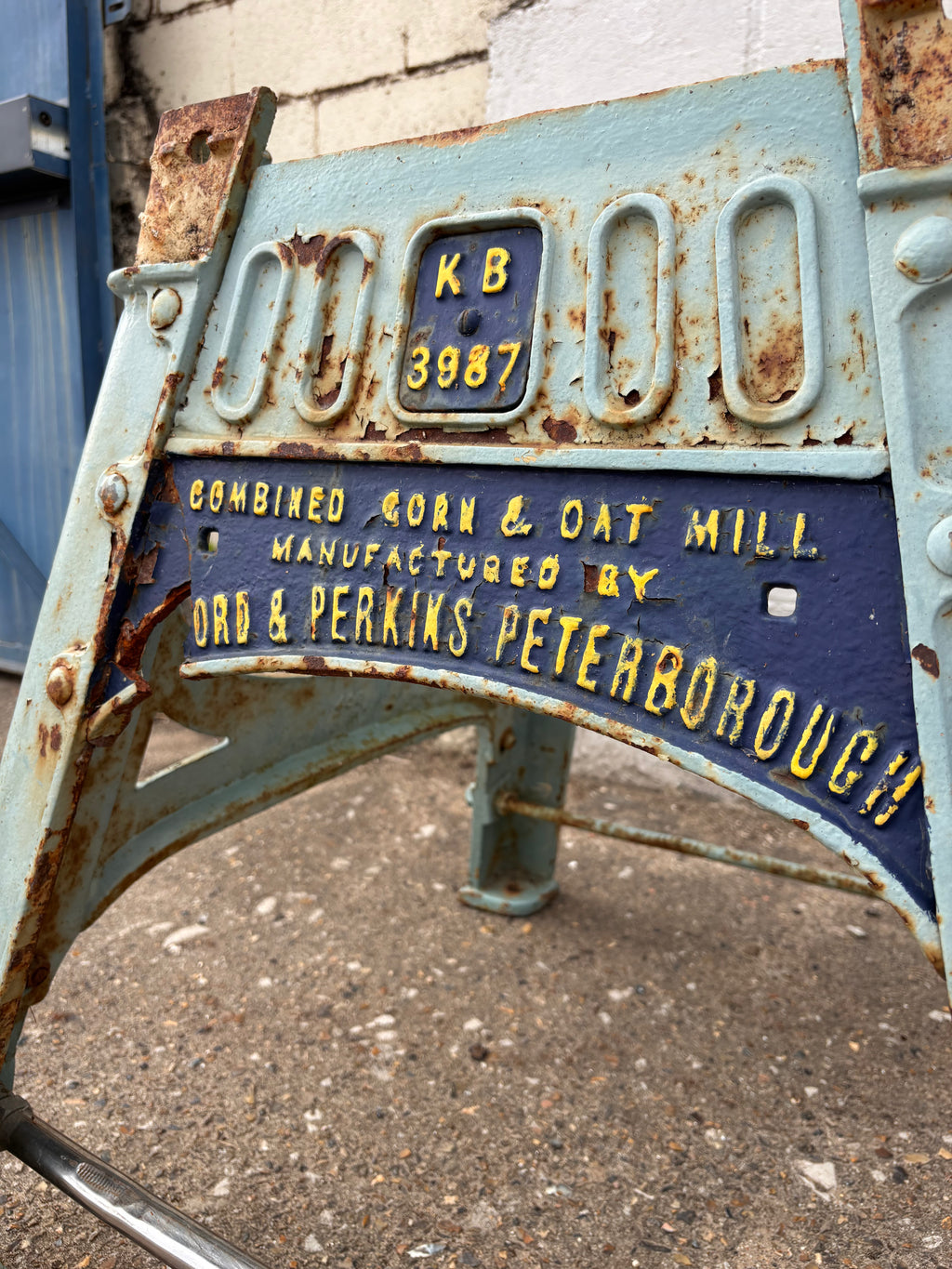 Rust-covered metal stand with text on a concrete surface